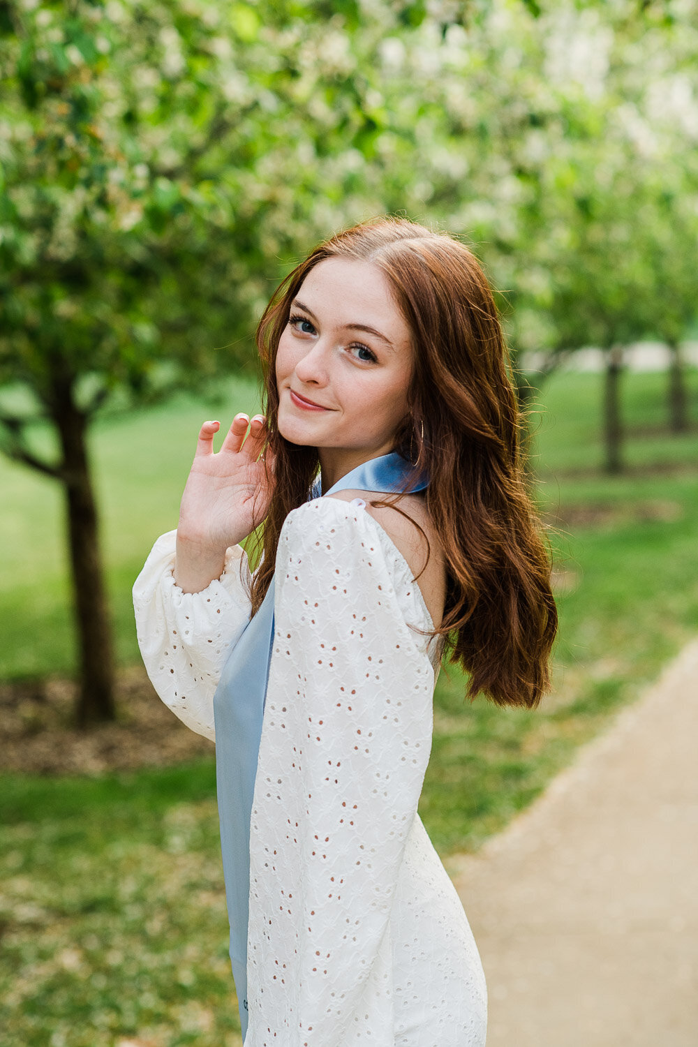 grad girl with sash by trees