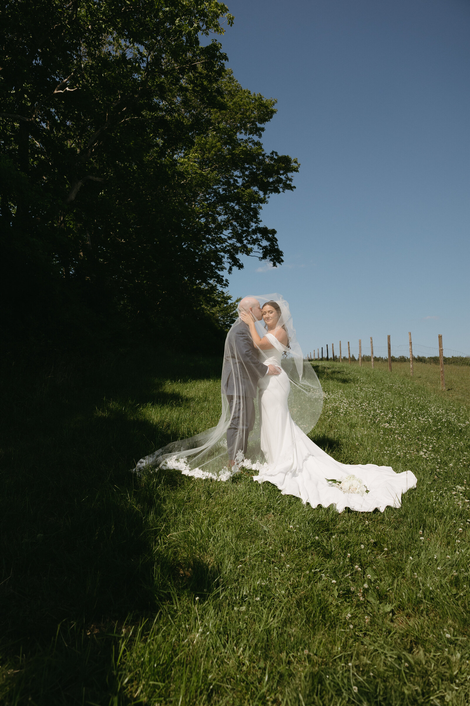 A couple poses for a bridal portrait after getting married at the Farm at South Cove in Lunenburg, Nova Scotia. 