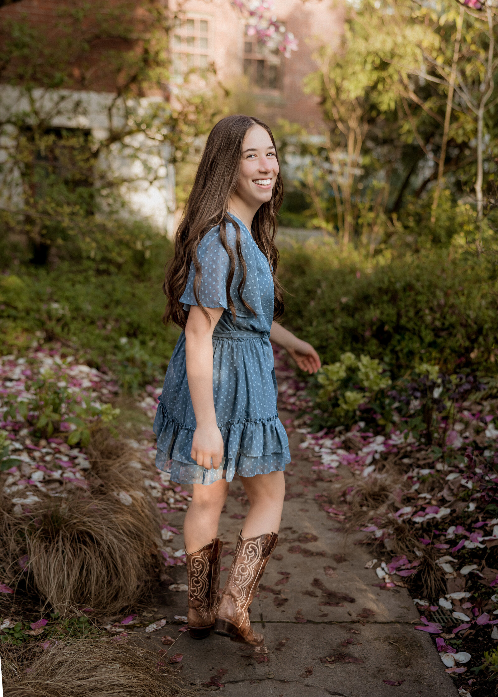 Girl wearing blue dress next to magnolia tree at mcmenamins edgefield