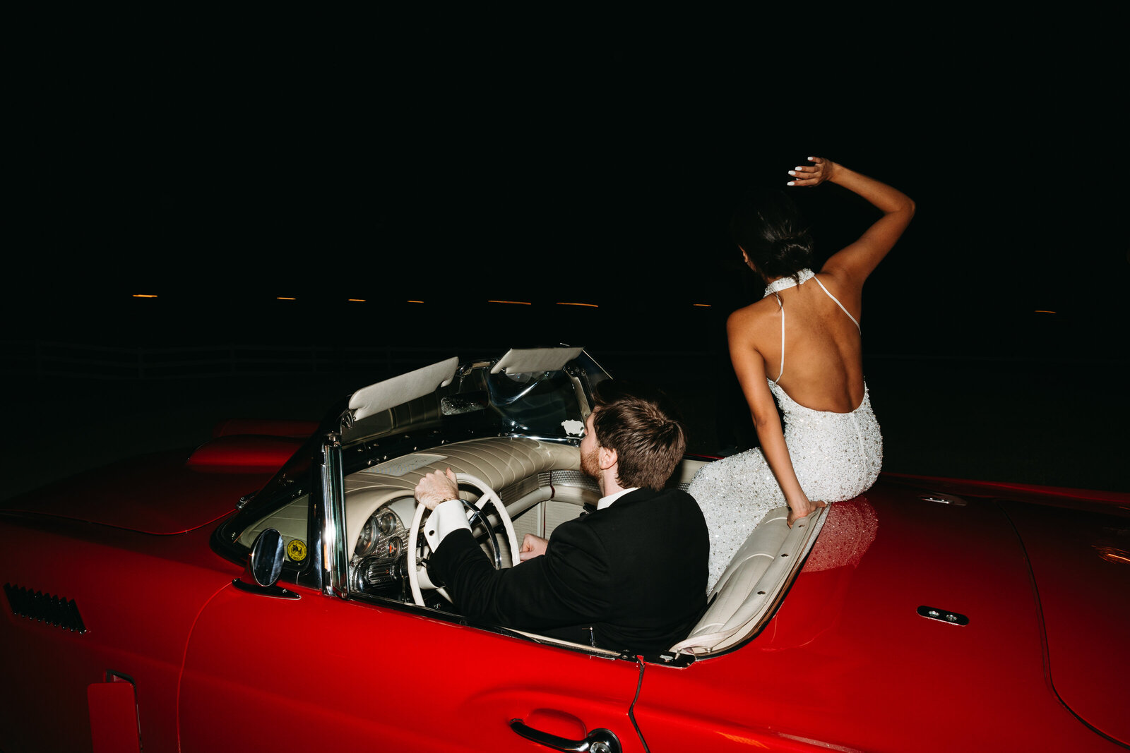 Bride and groom driving away in  Thunderbird car