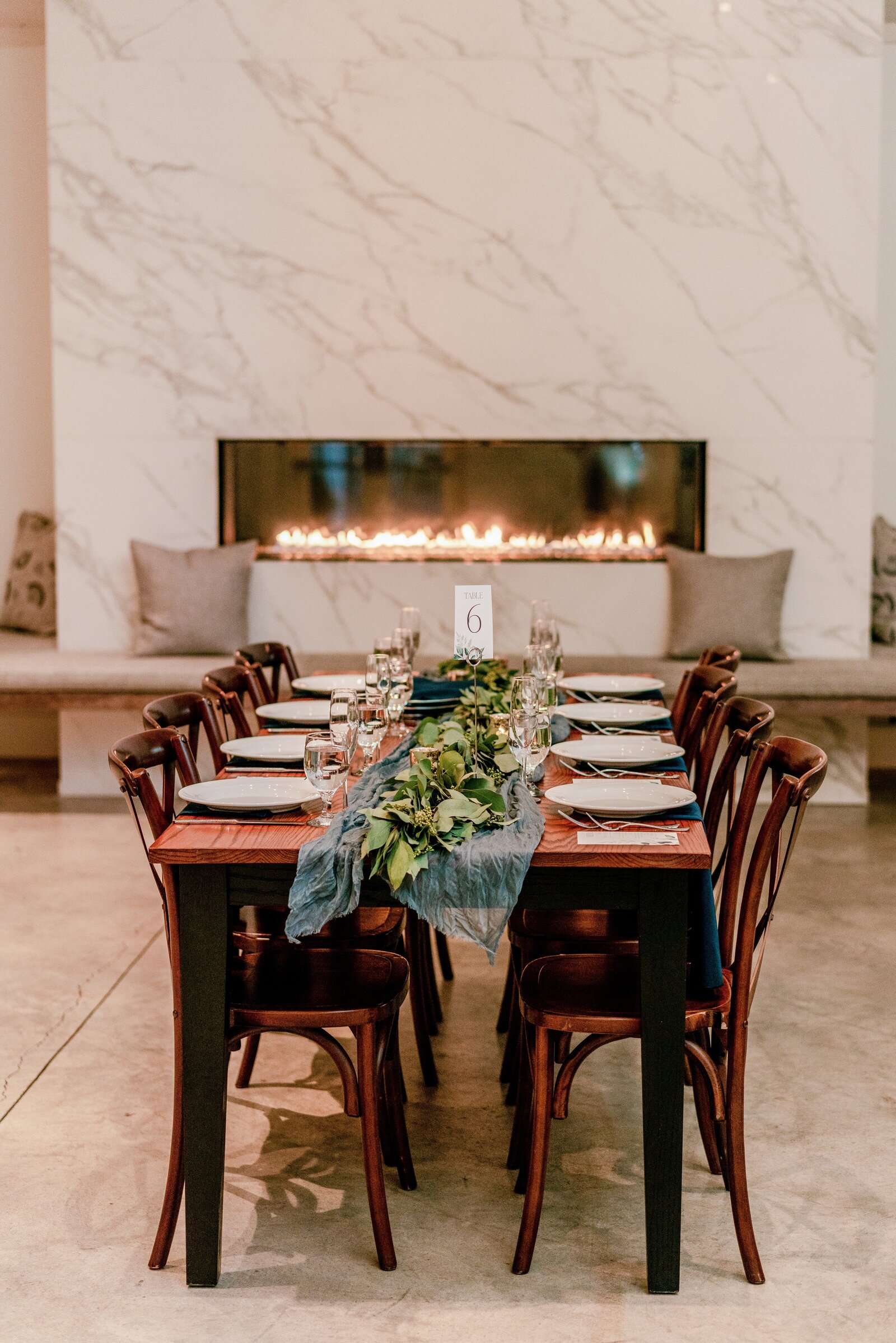A reception table in front of a marble fireplace for a wedding at Fleetwood Farm Winery in Loudoun County