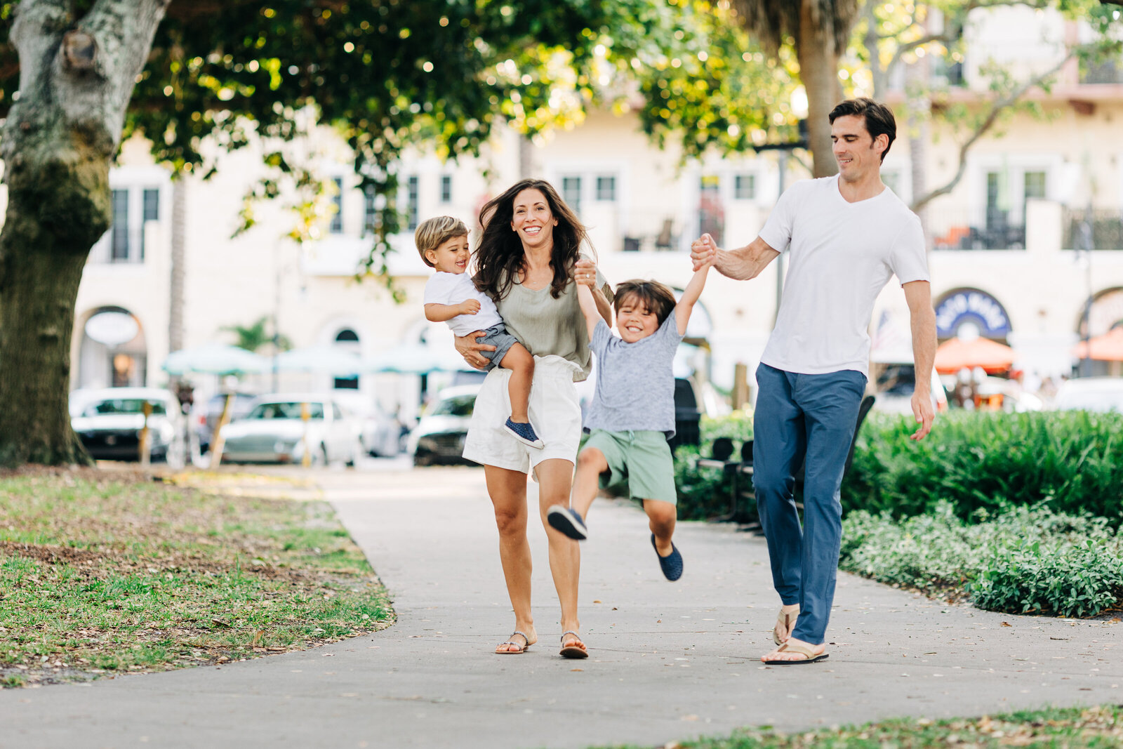 fun family photo of a family of 4 walking downtown in st. pete florida