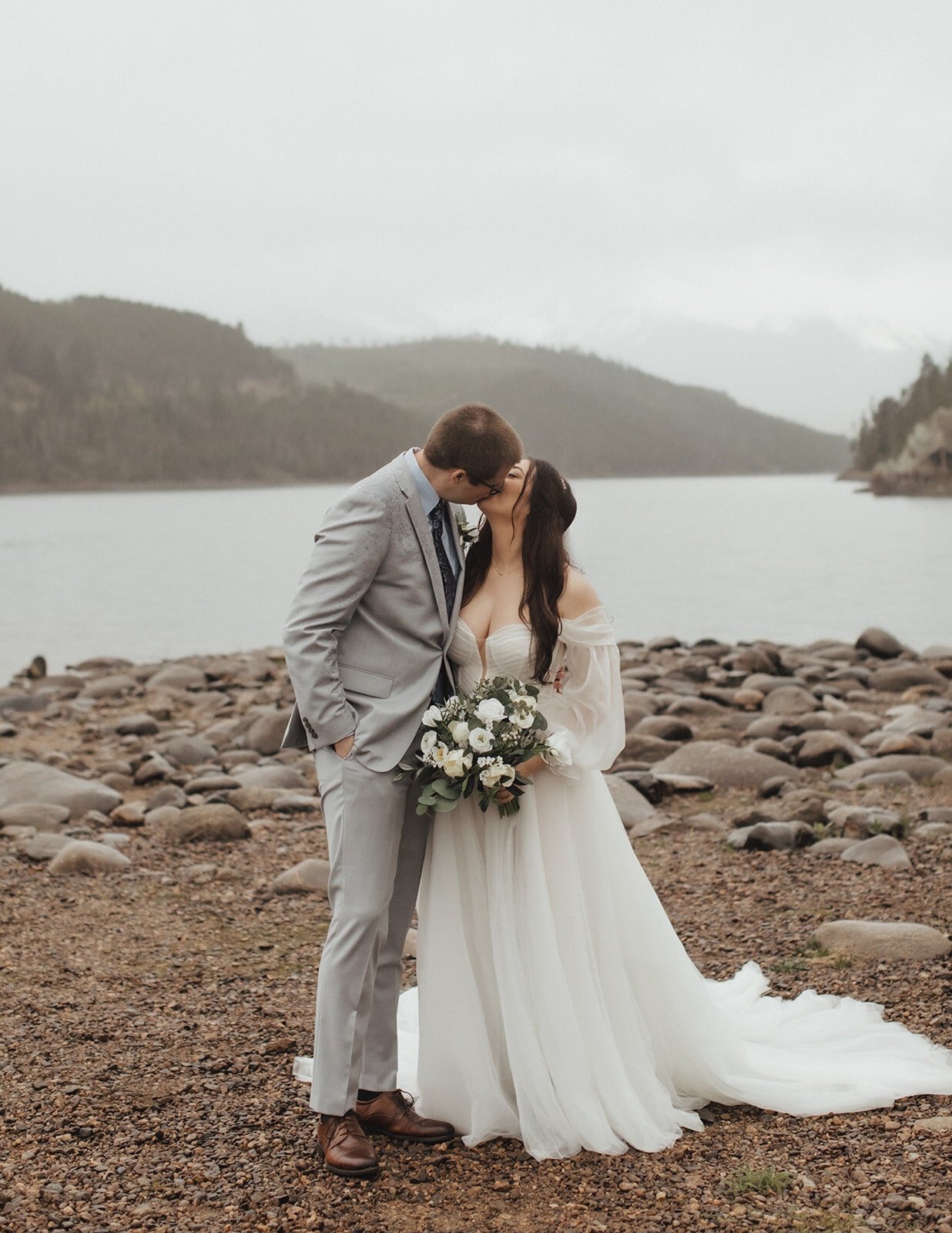 Bride and groom kissing each other on the lakeside