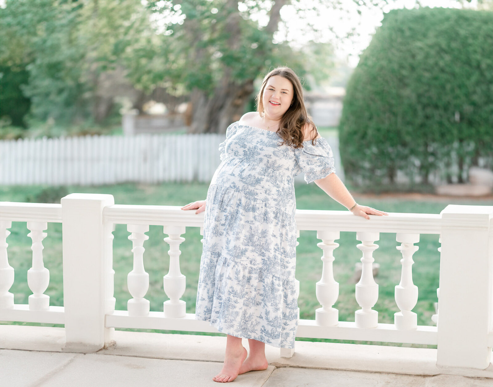 Pregnant woman stands on a porch at Carnton Plantation 