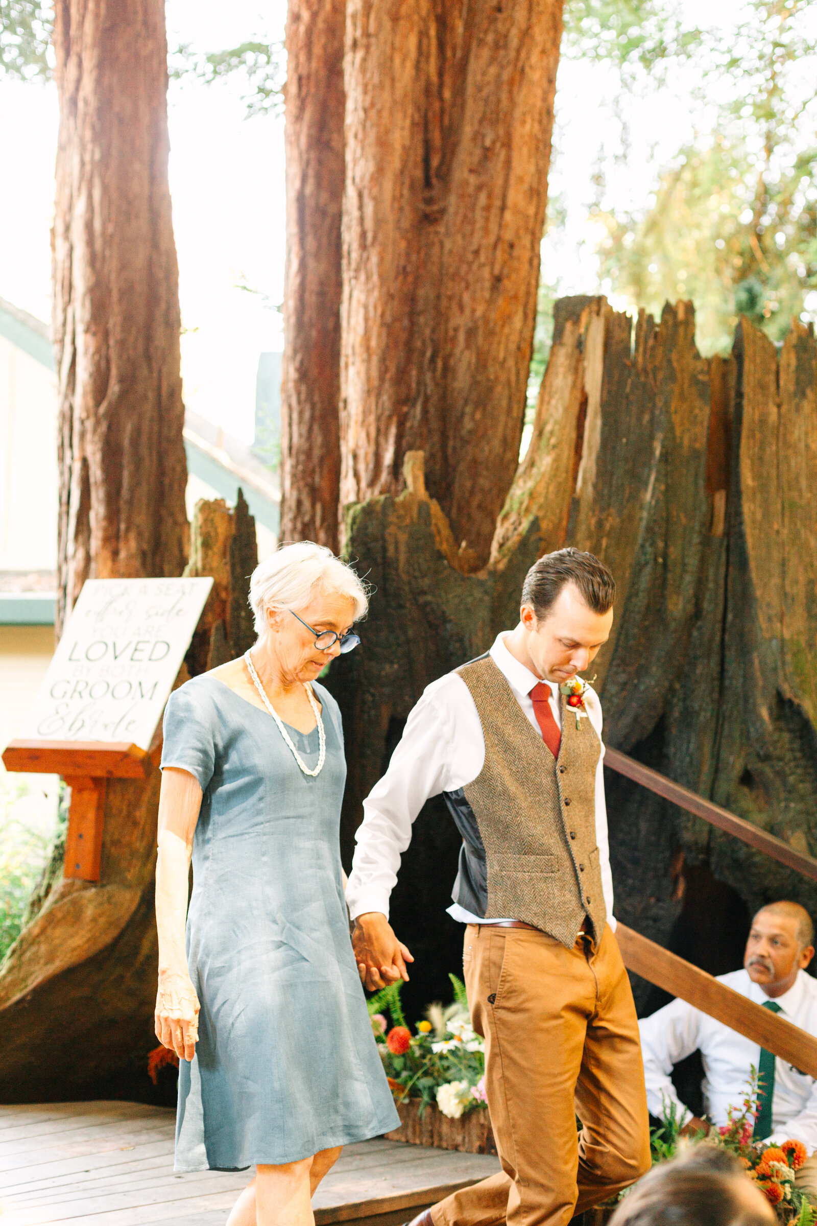 Mother of the groom and groom at their colorful wedding ceremony in Santa Cruz, California in the redwood trees.