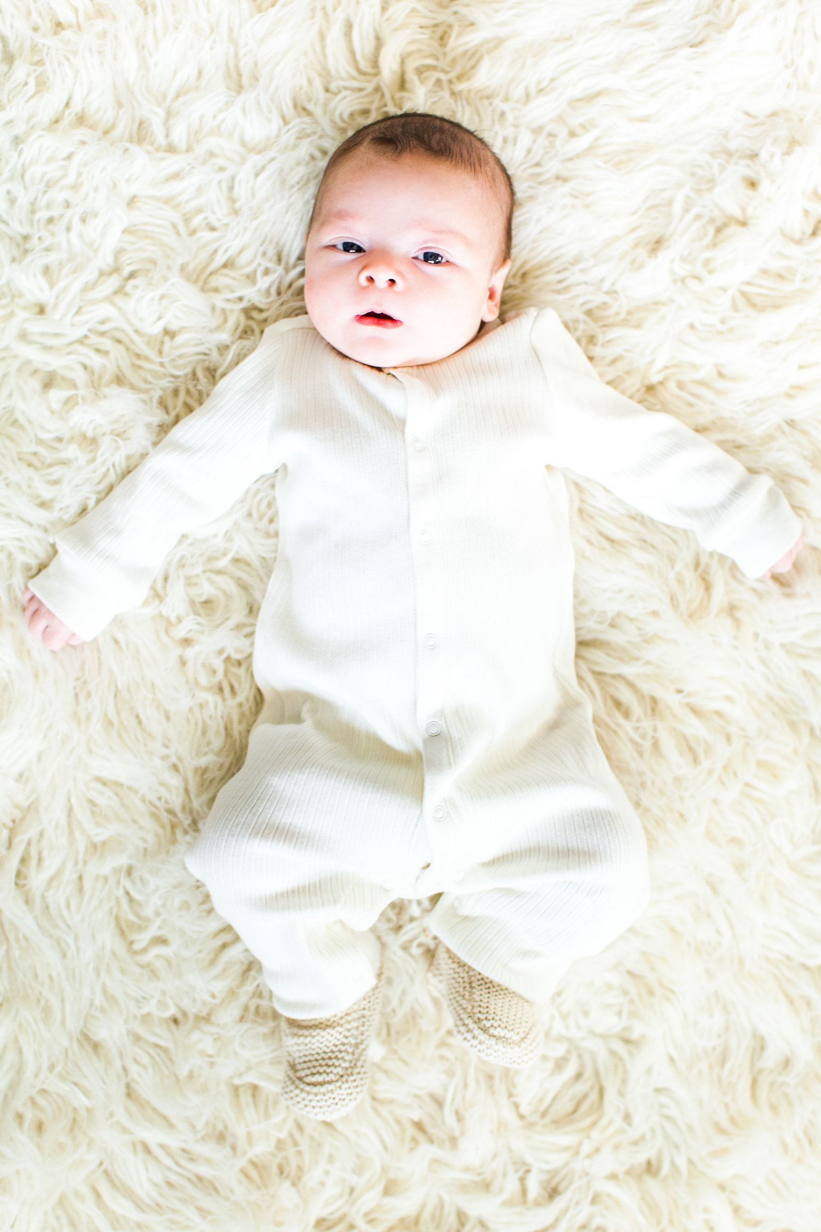 Newborn on faux fur rug in all white