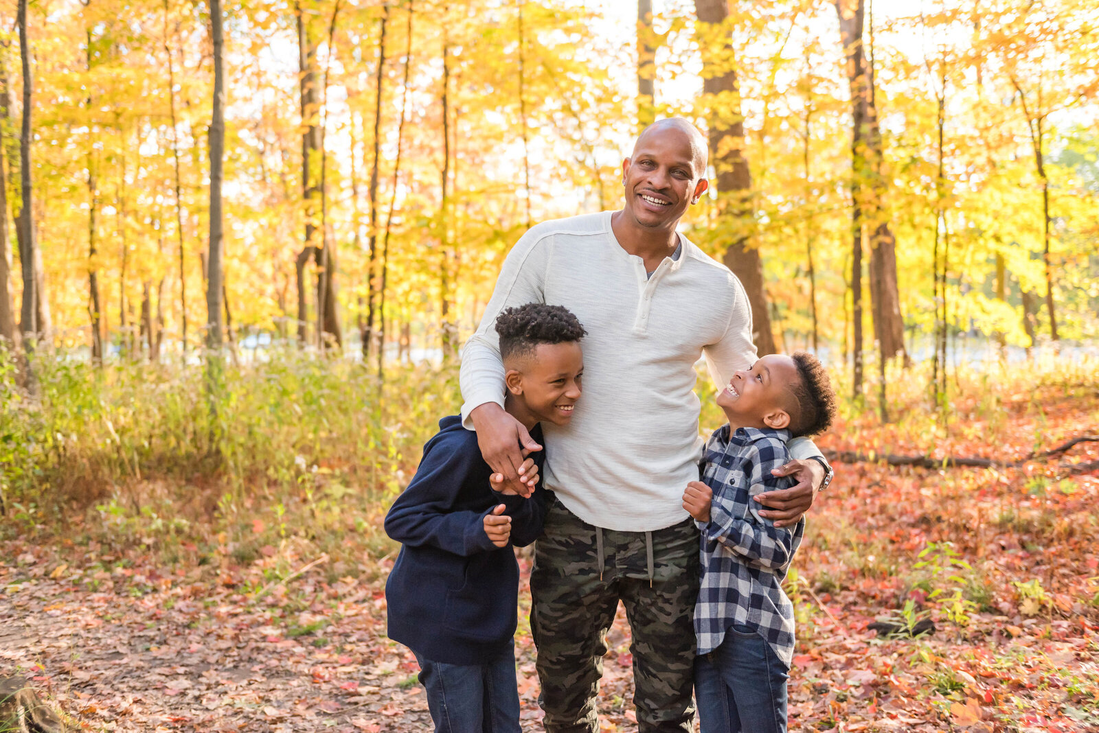 Dad hugging his two young sons during their fall family photos by Chicago Family Photographer Kristen Hazelton