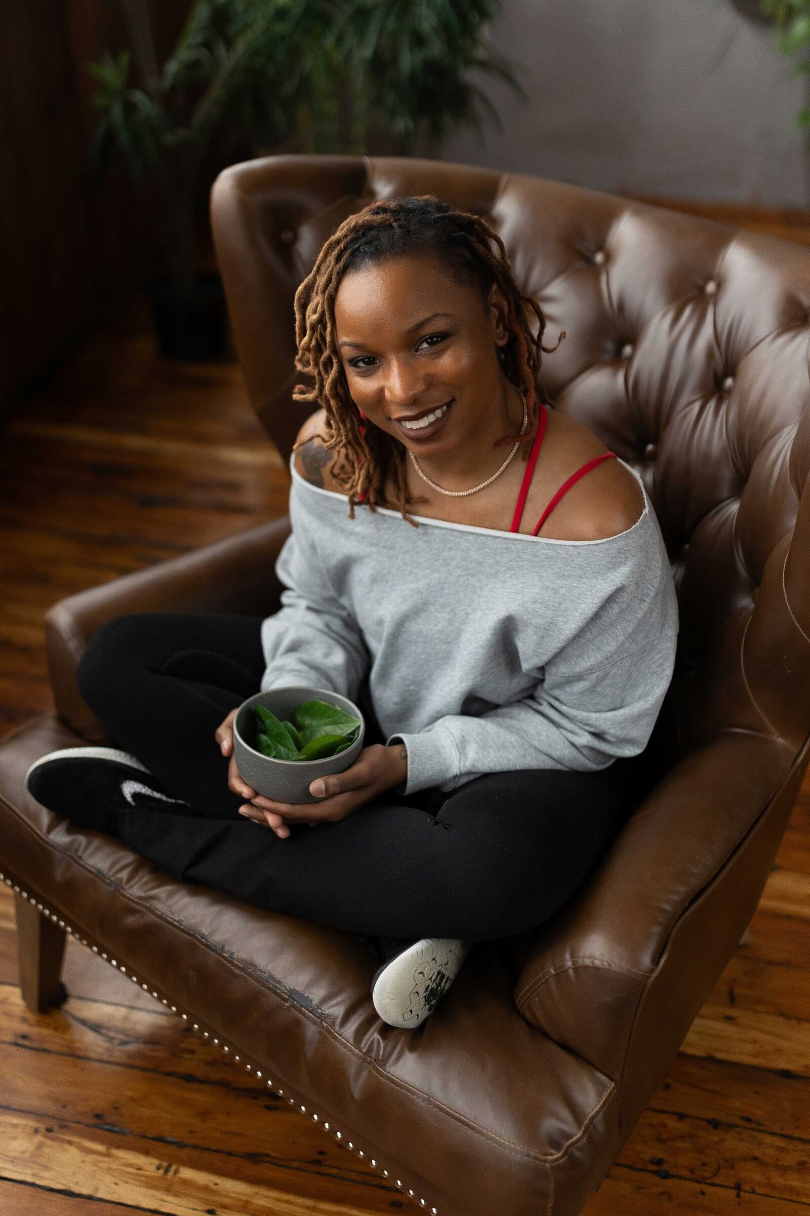 woman sitting on a couch while holding a tea