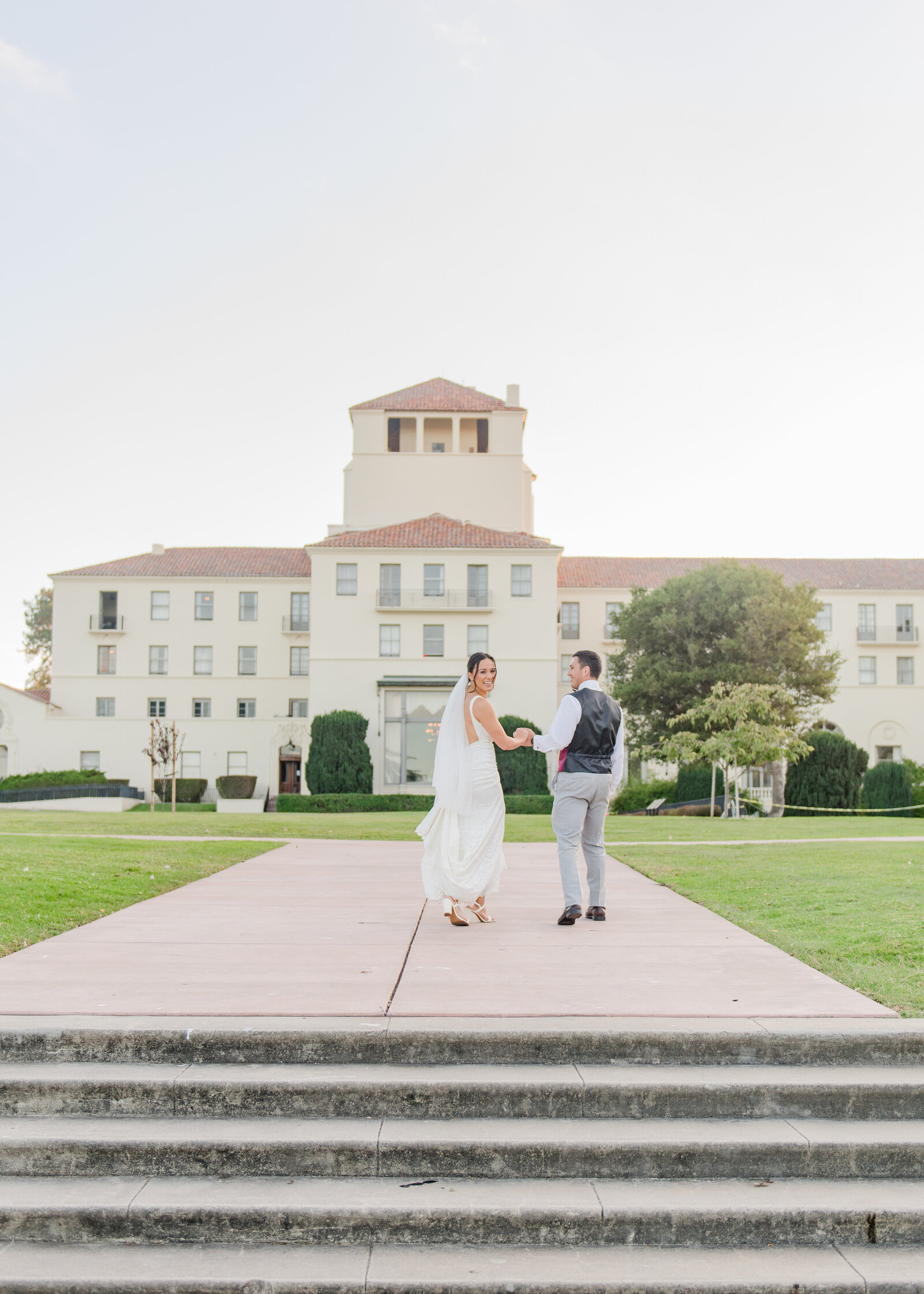 wedding couple walking away from camera at their wedding in monterey