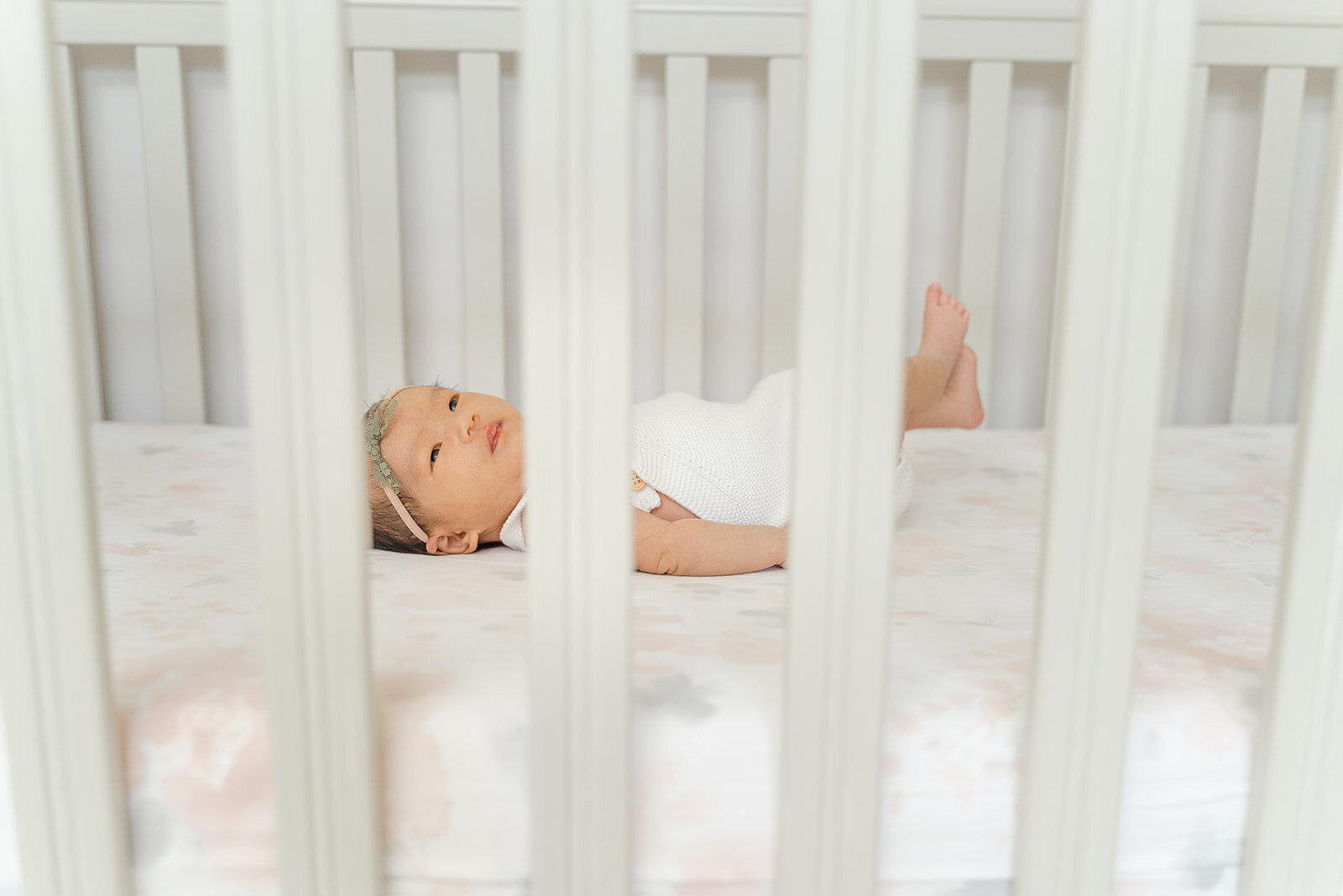 baby girl in the crib during newborn picture in Ashburn, Virginia