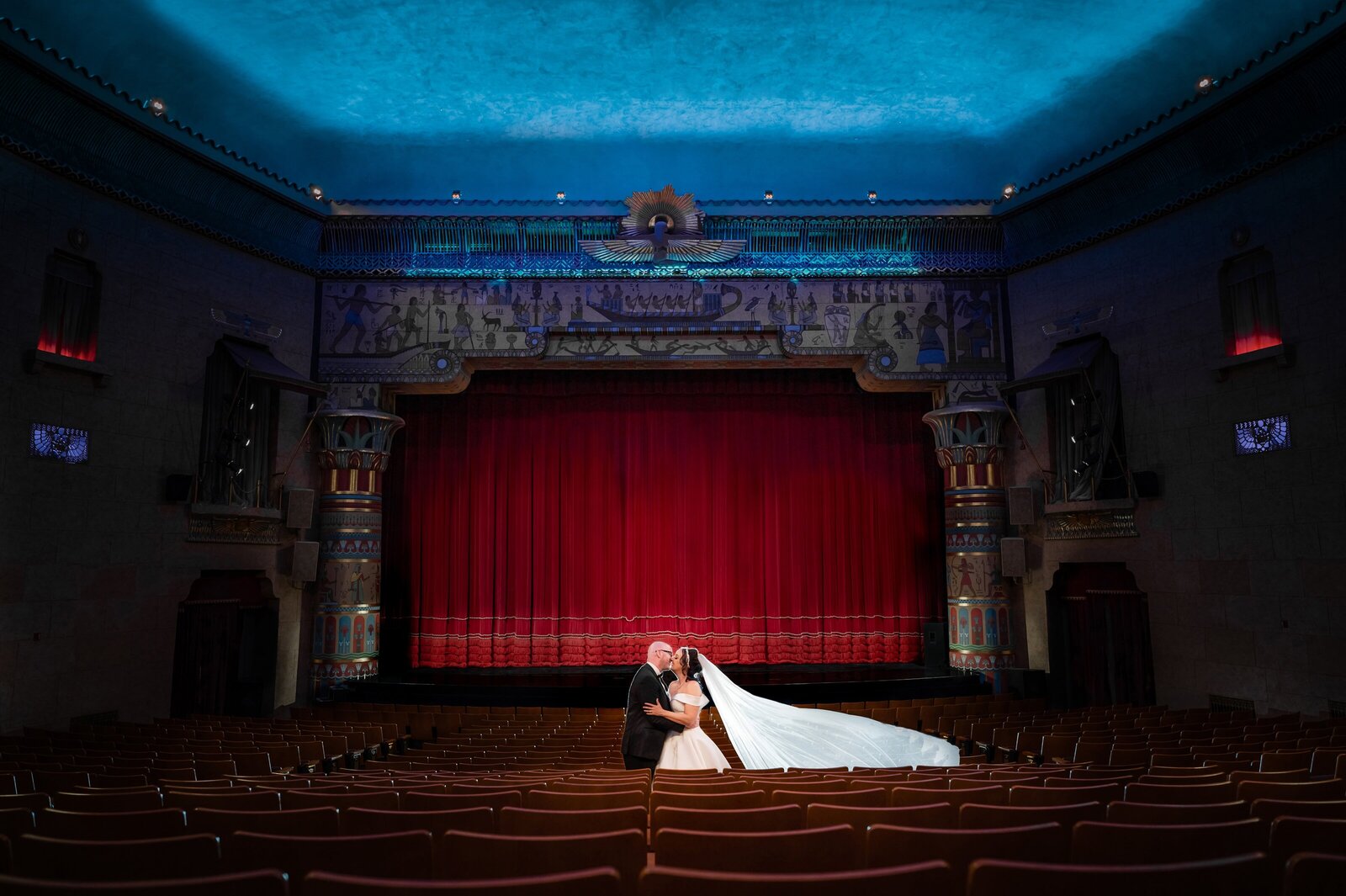 Bride and groom share a moment during their theater wedding day in an empty theater.