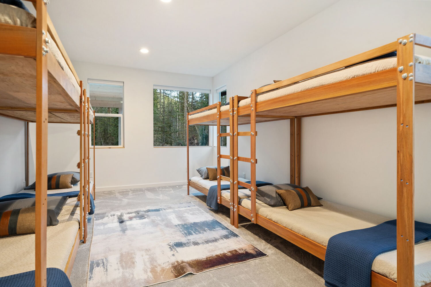Bunk bed room with four wooden beds and navy bedding