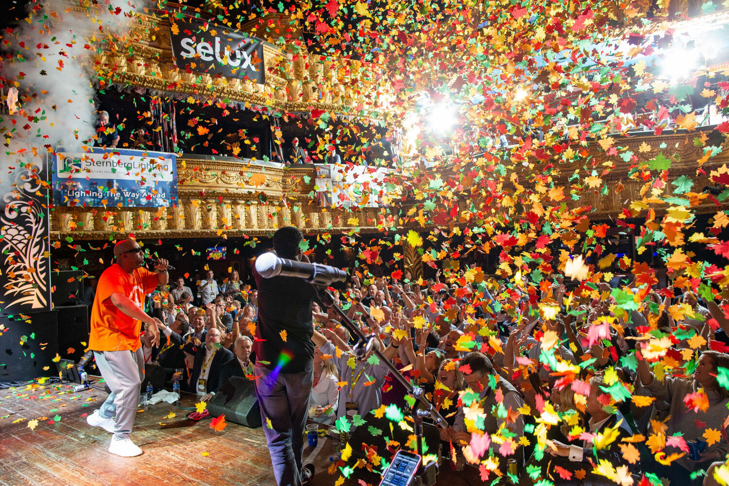 Performer on stage as colorful confetti rains over the crowd