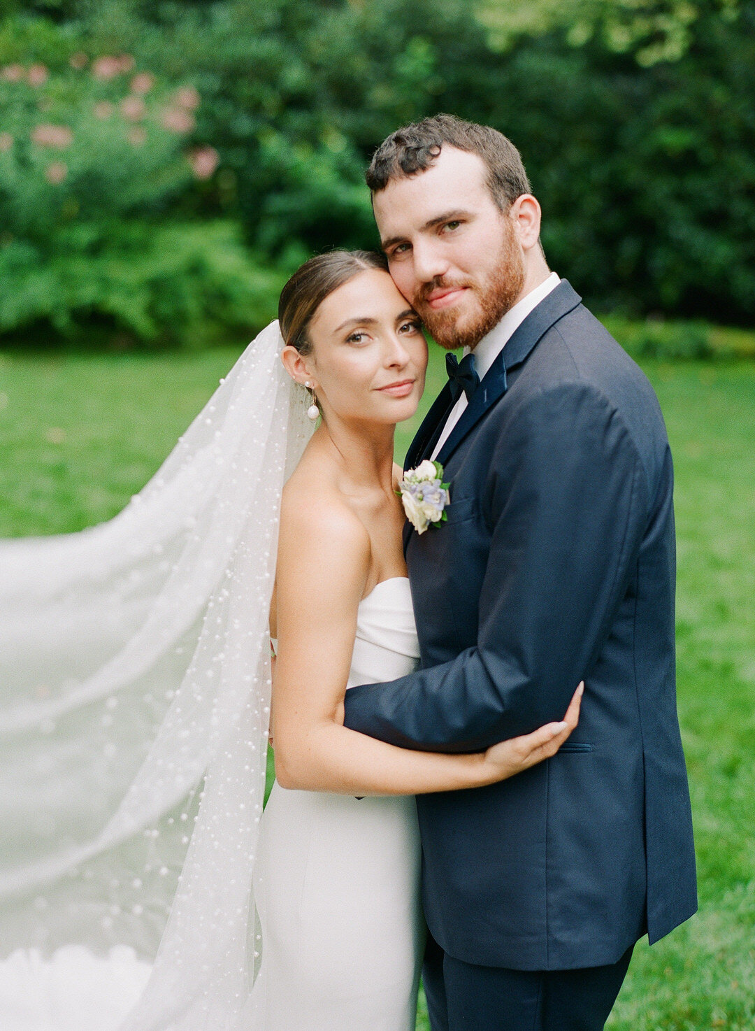 Bride and Groom Hugging Faces close together with brides veil sweeping in front