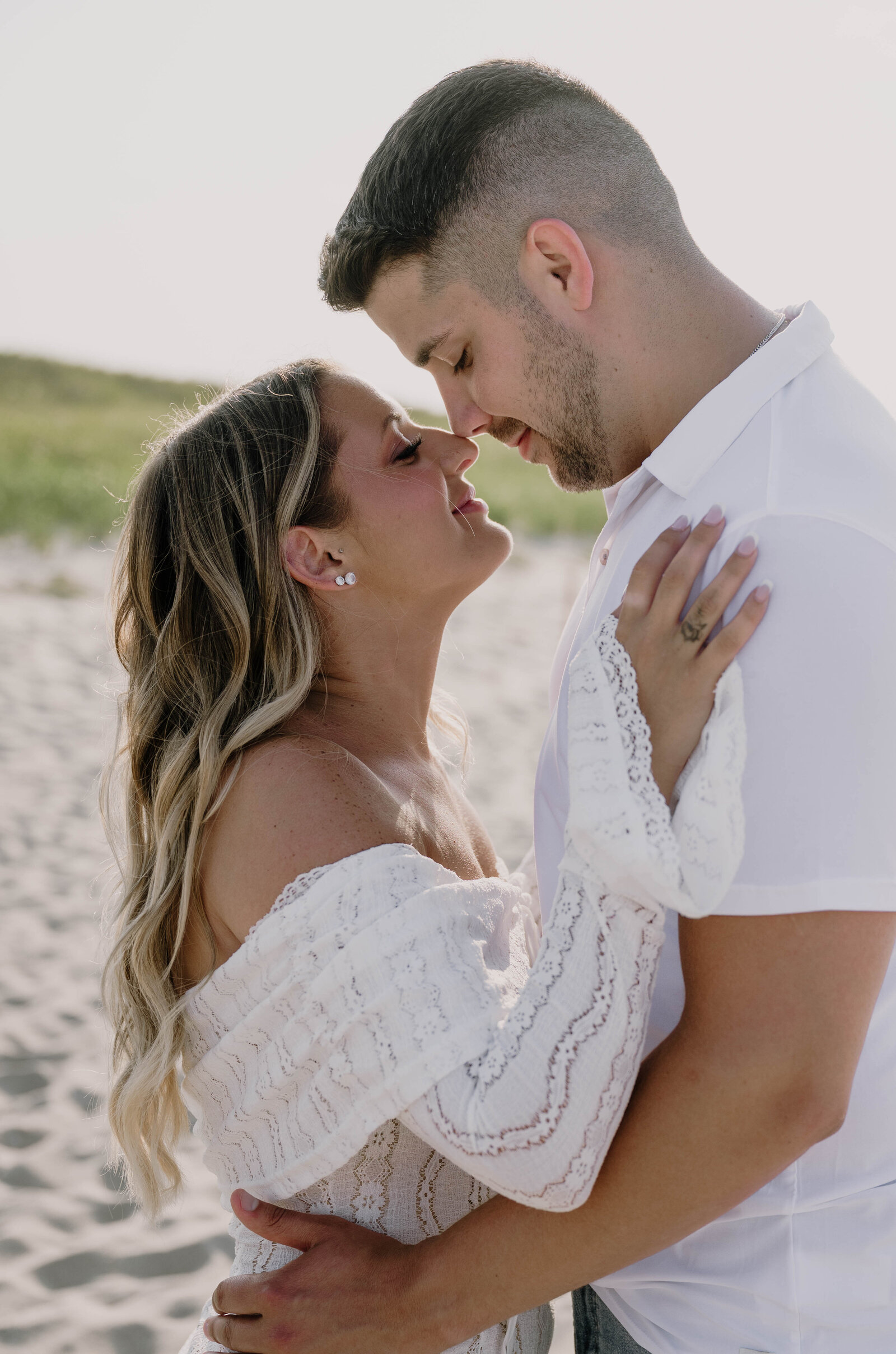 Engaged Couple cuddling up together on Scusset Beach in Massachusetts during their engagement session