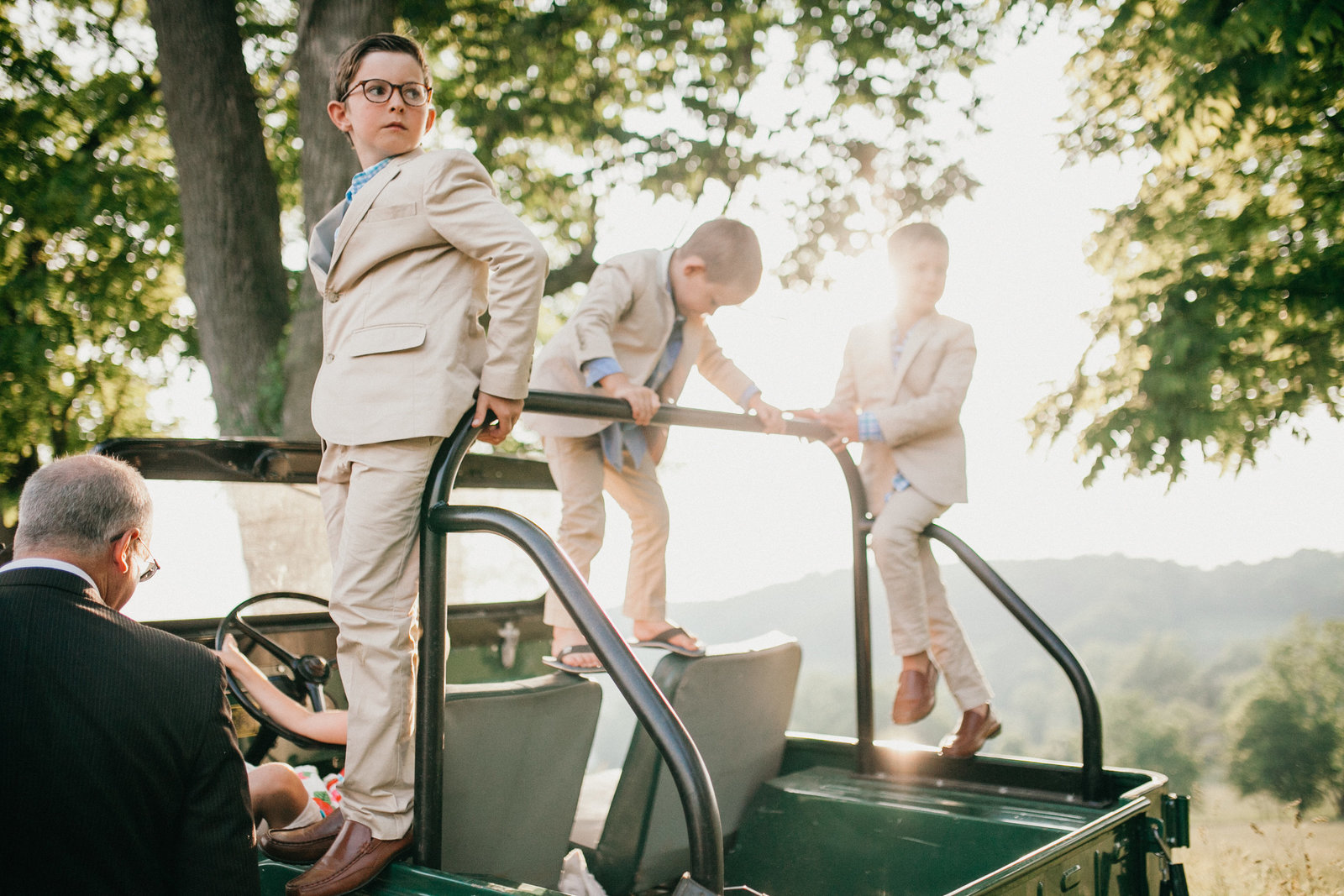 Kids wearing coordinating outfits climb on this old jeep.