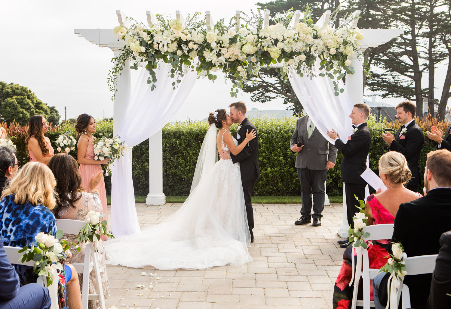 Bride and groom kissing during their wedding ceremony