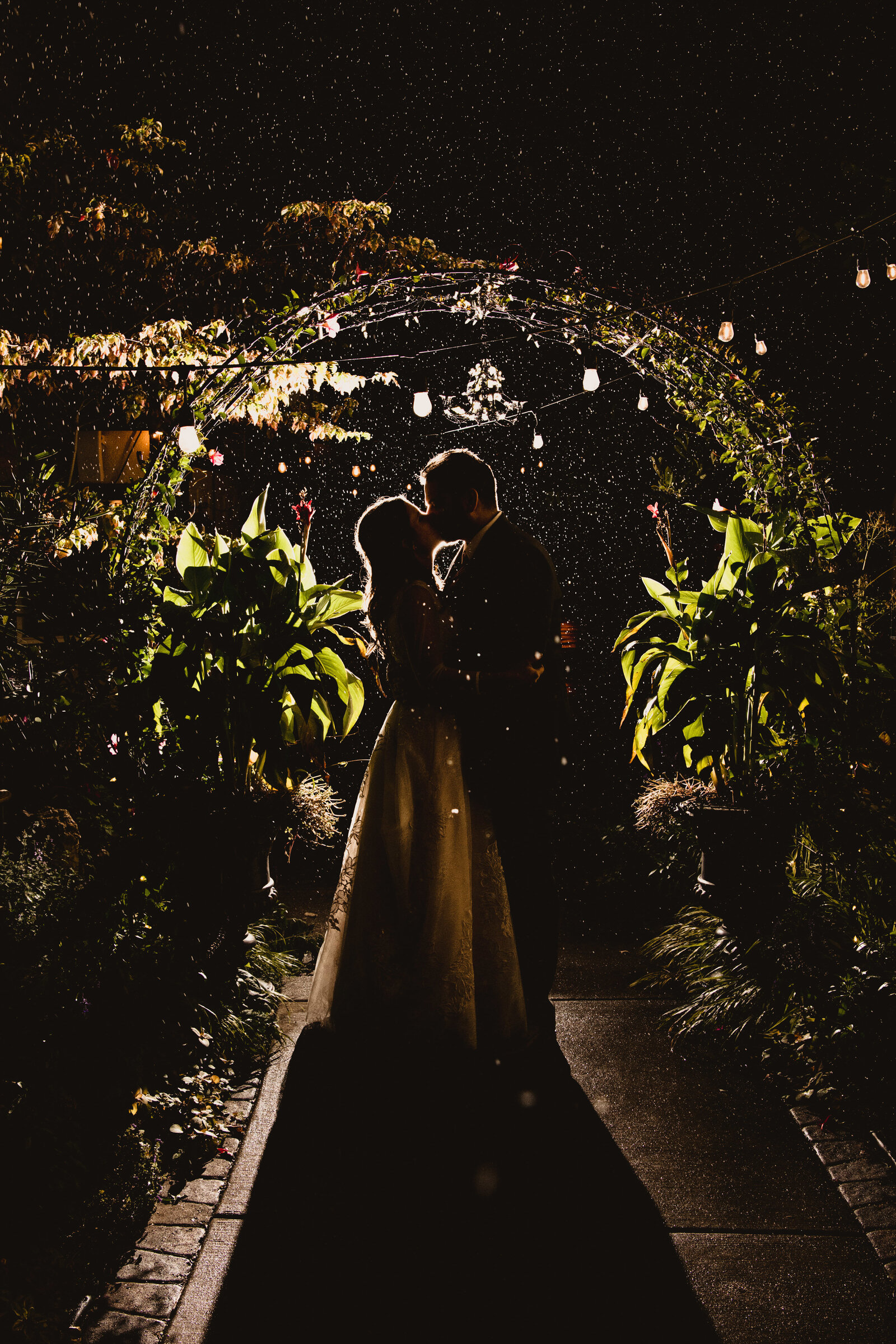 Bride and groom kiss in the falling snow.