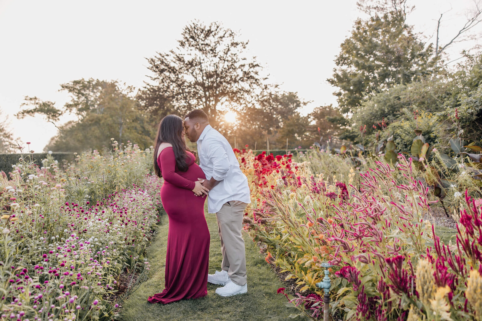 Pregnant woman and husband in flower garden at Harkness Memorial State Park