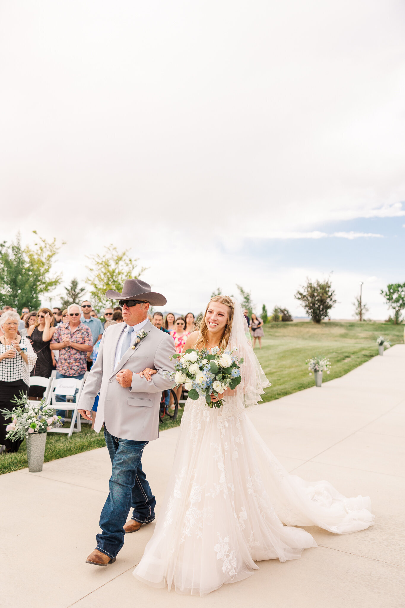 Bride walking down the aisle with her father at a Loma, Colorado wedding ceremony at Absolute Prestige Limo and Venue.