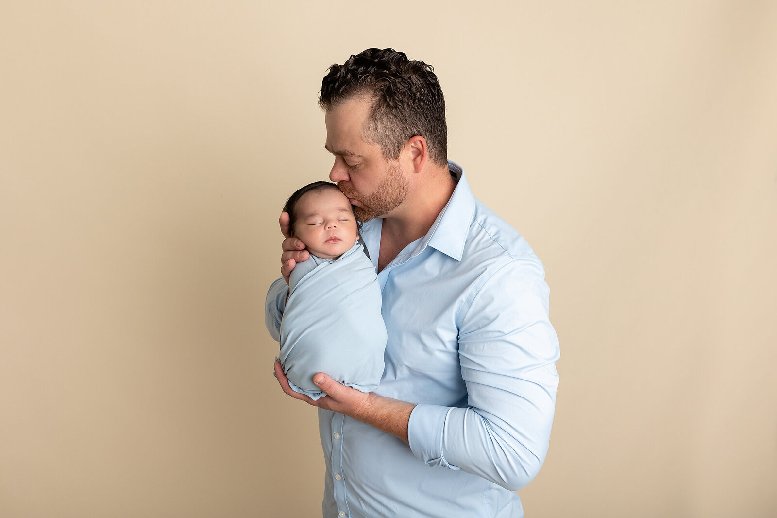 dad holding newborn son by Newborn Photography Bucks County PA