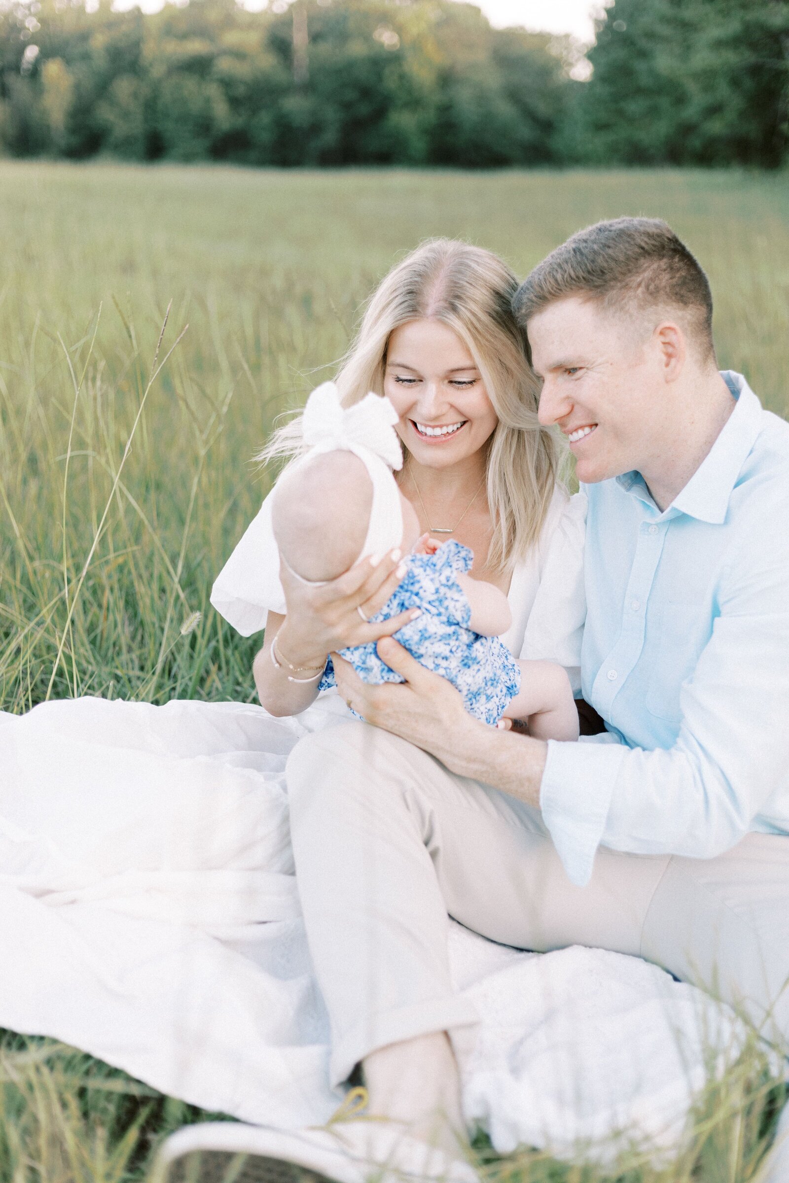 parents smiling at baby in family photos in peoria illinois