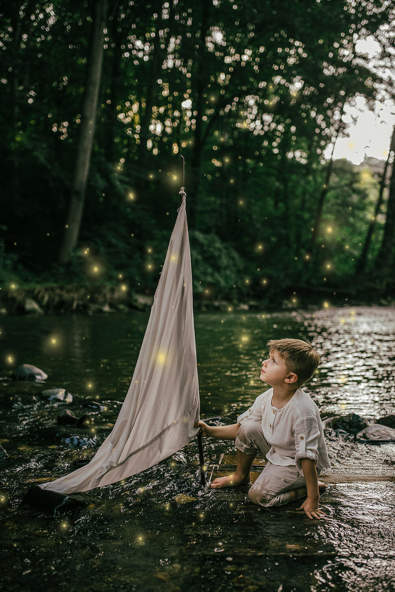 Boy sitting on  raft in a creek with a pillowcase sail at night with fireflies in Jerusalem Mill Kingsville Maryland