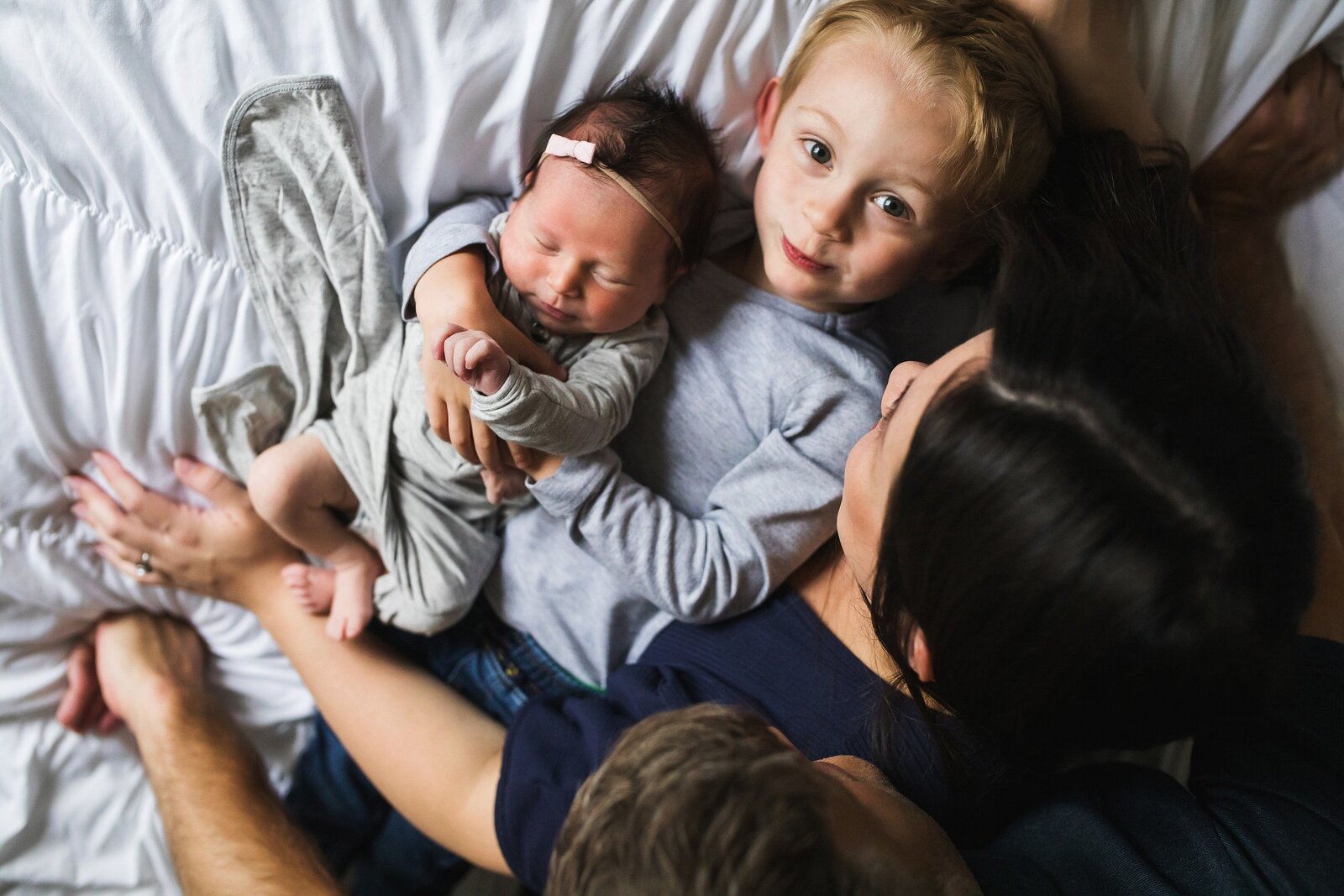 Big brother holding newborn baby sister during Seattle newborn photography session