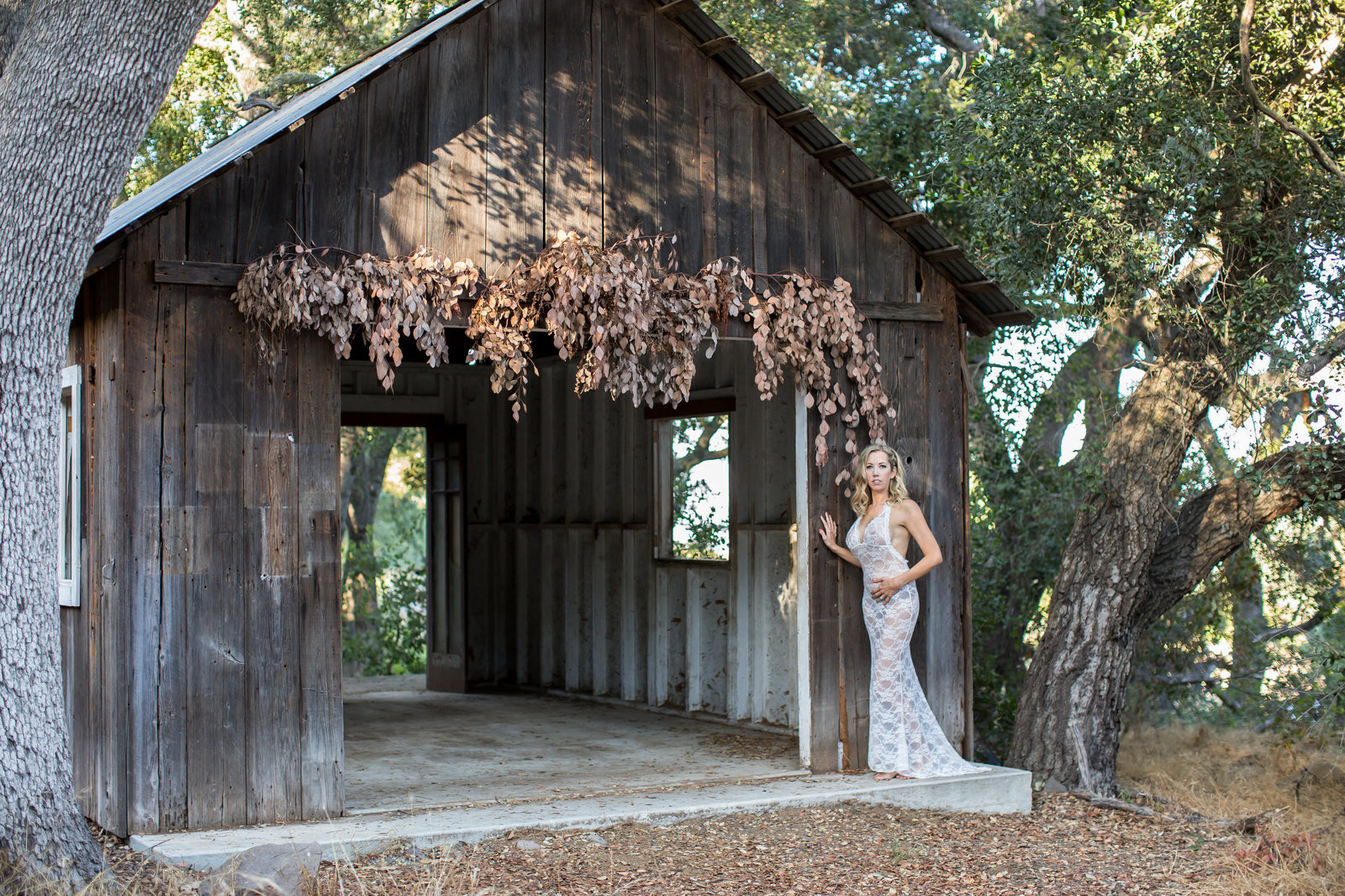 Woman wearing white dress near covered bridge