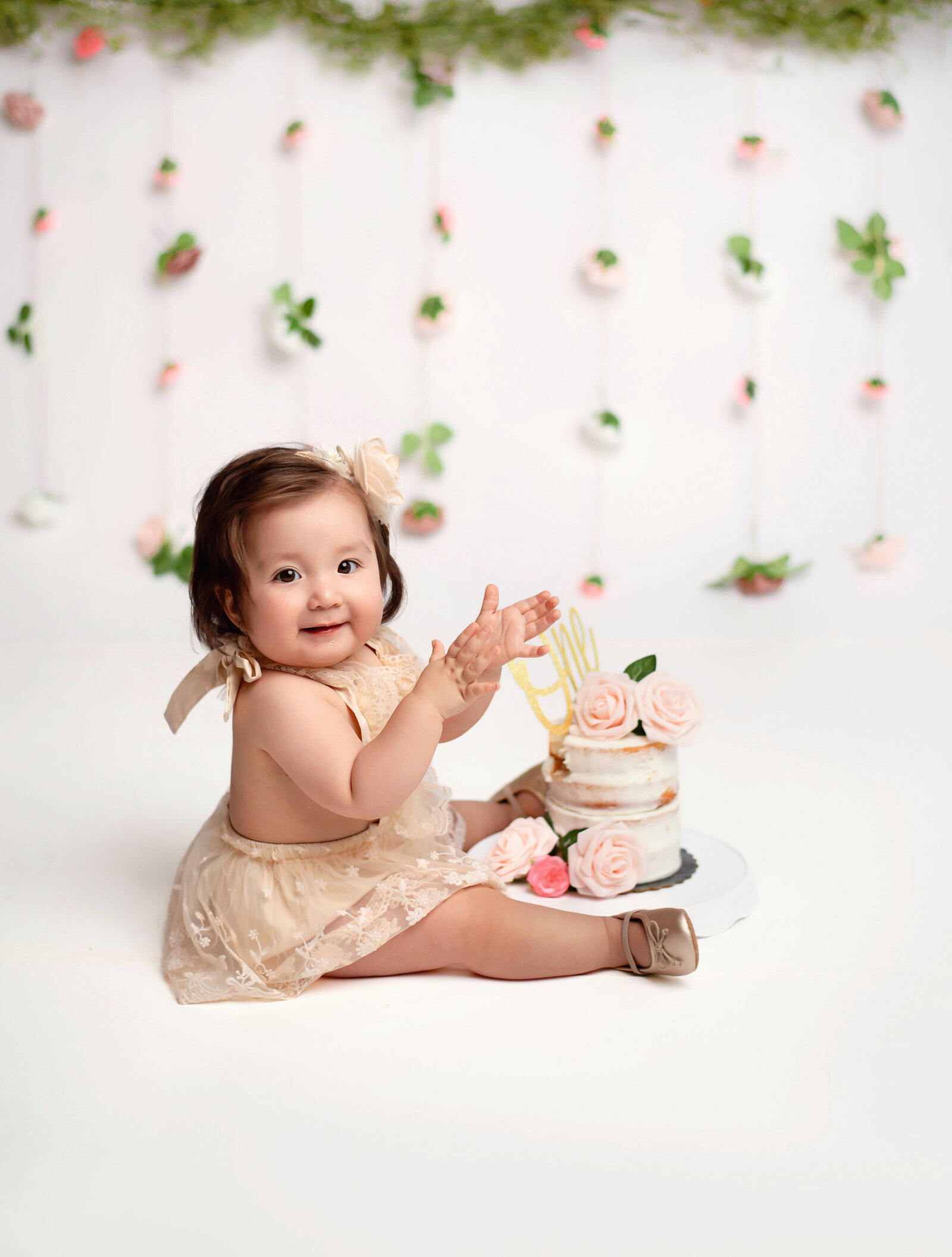 baby with a floral hanging backdrop