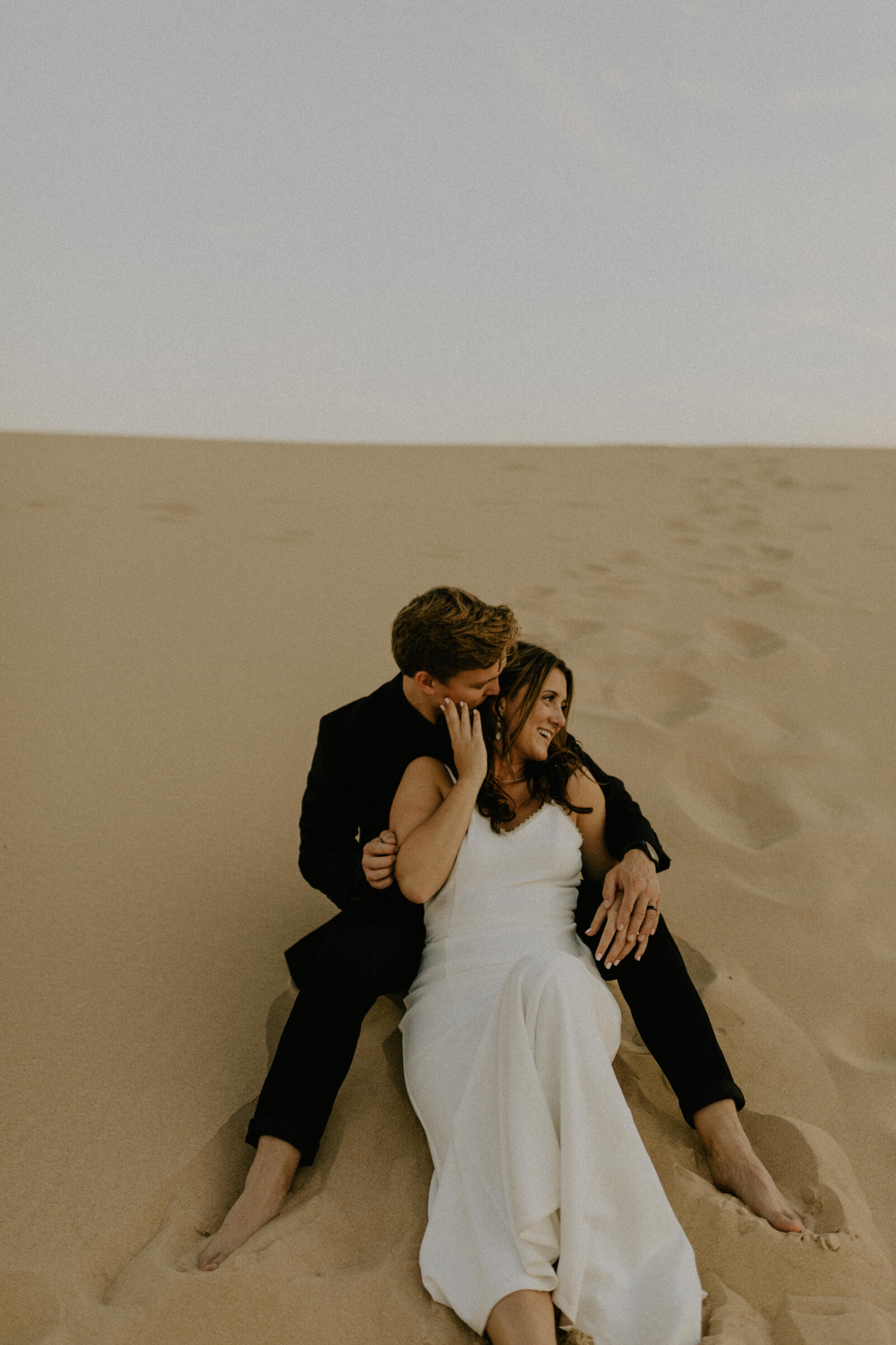 Couple sitting in the sand at Silver Lake Sand Dunes in Michigan