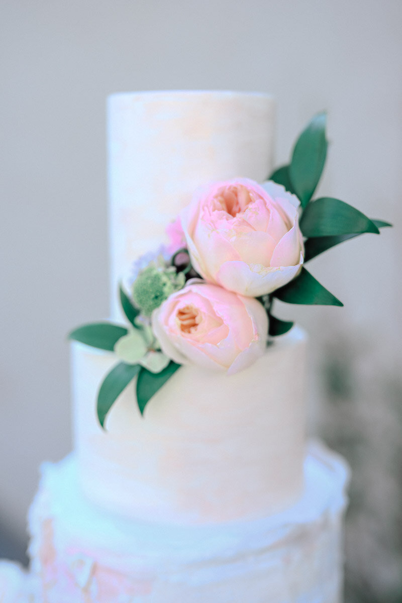 close up of simple wedding cake with floral accents