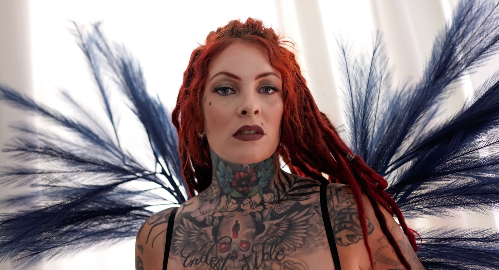 Savannah Georgia Boudoir Photography and Glamour boudoir portrait of Woman with tattoos and dreadlocks standing in curtains really close up