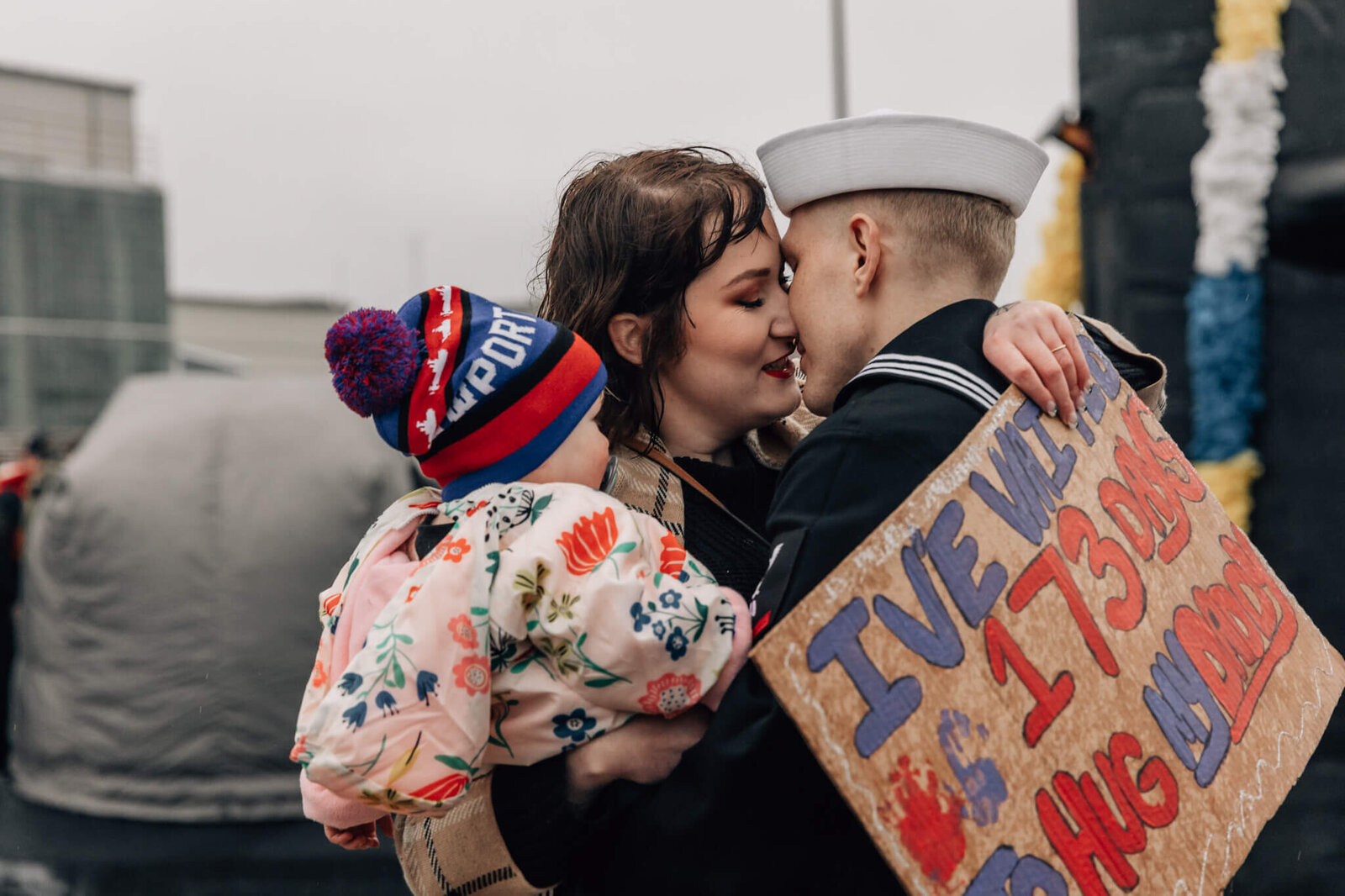 Sailor hugs wife and child at emotional homecoming from a 173 day deployment aboard USS Newport News.