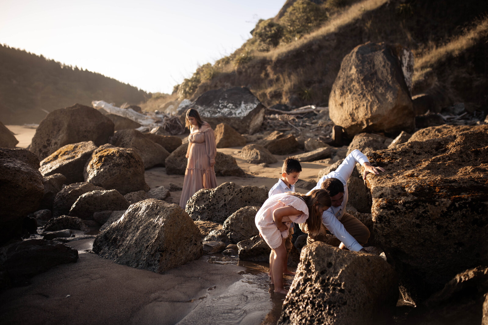Children exploring the rocks at Waipatiki Beach during a relaxed family photo session – natural, storytelling photography in Hawke’s Bay.