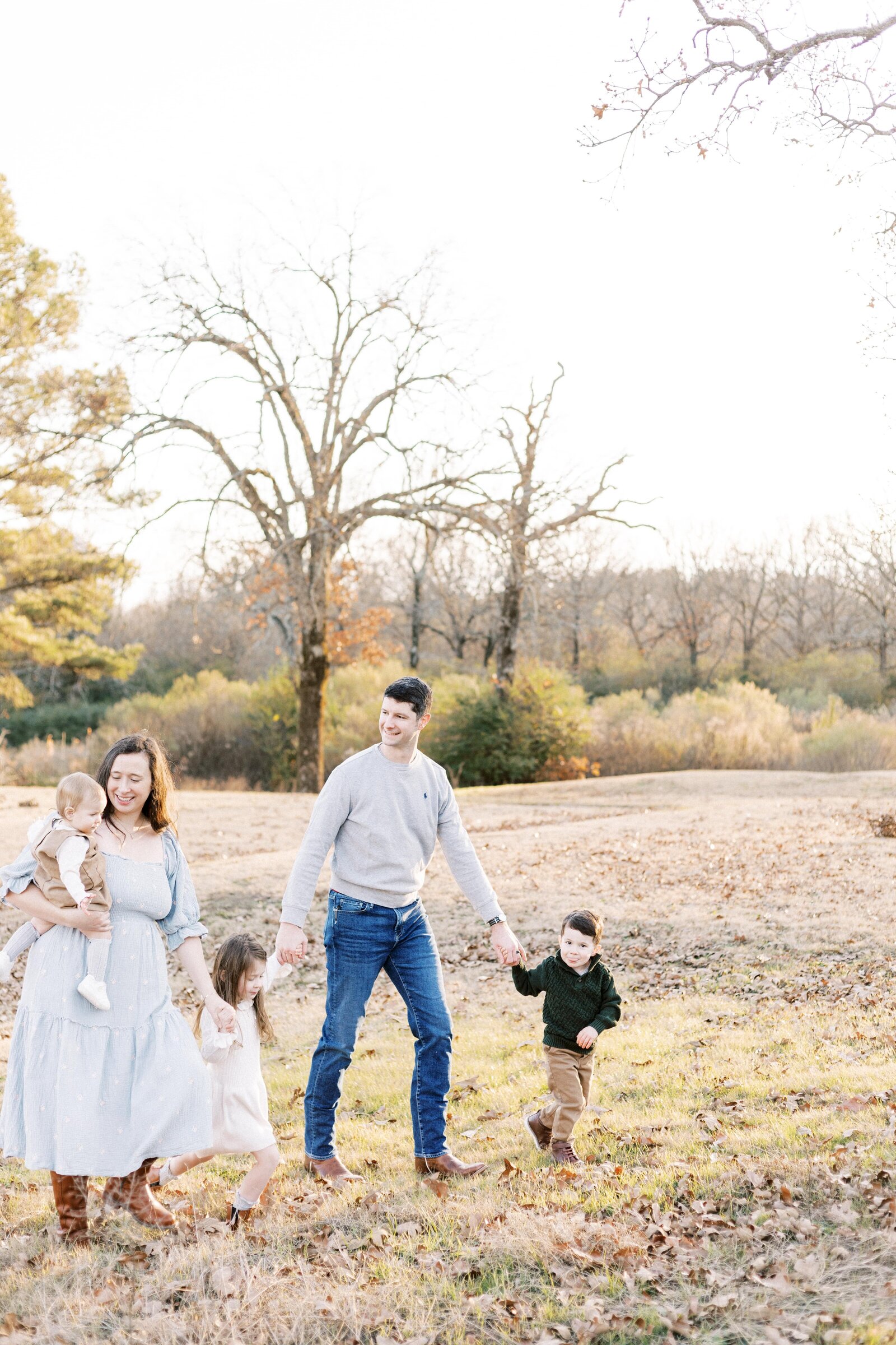 family walking up the hill and holding hands in sunset peoria illinois family photos 