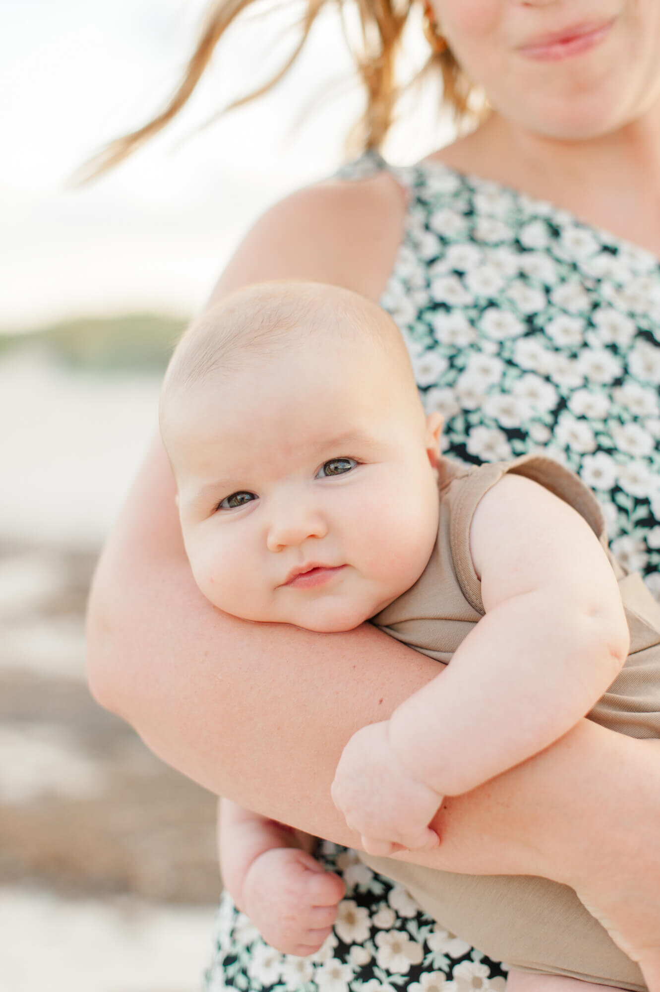 Closeup image of mom holding young infant boy with chunky cheeks