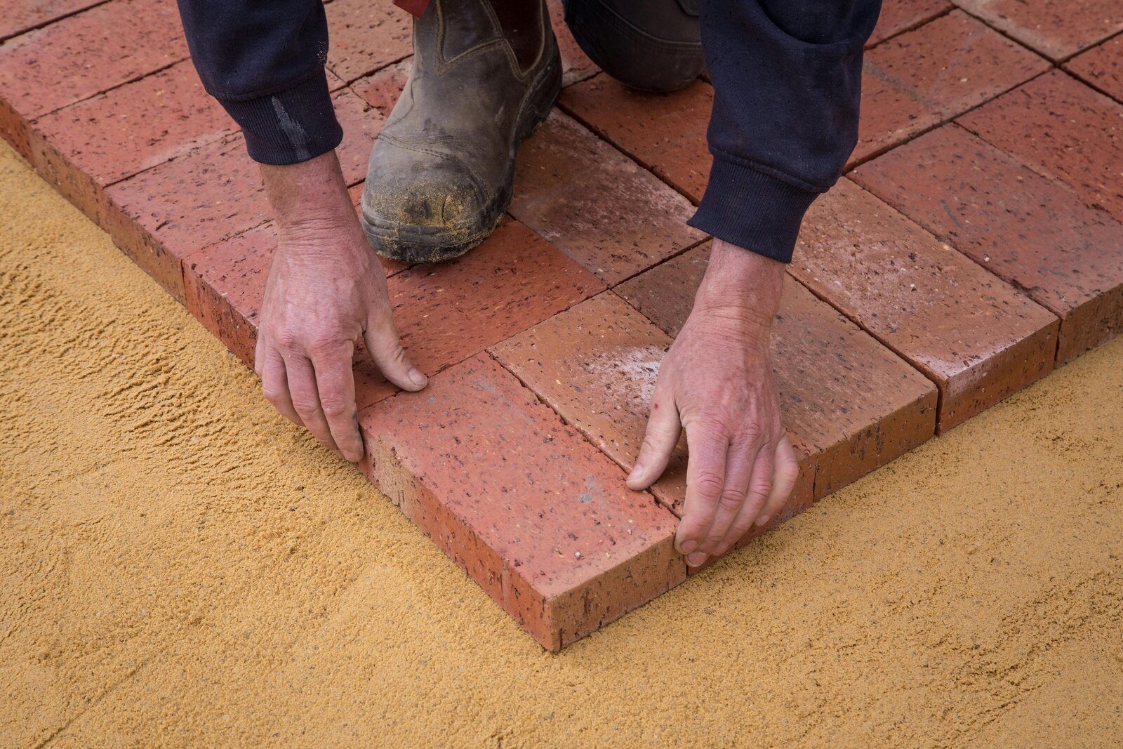 A workman creates and outdoor patio from bricks in Missoula, MT.