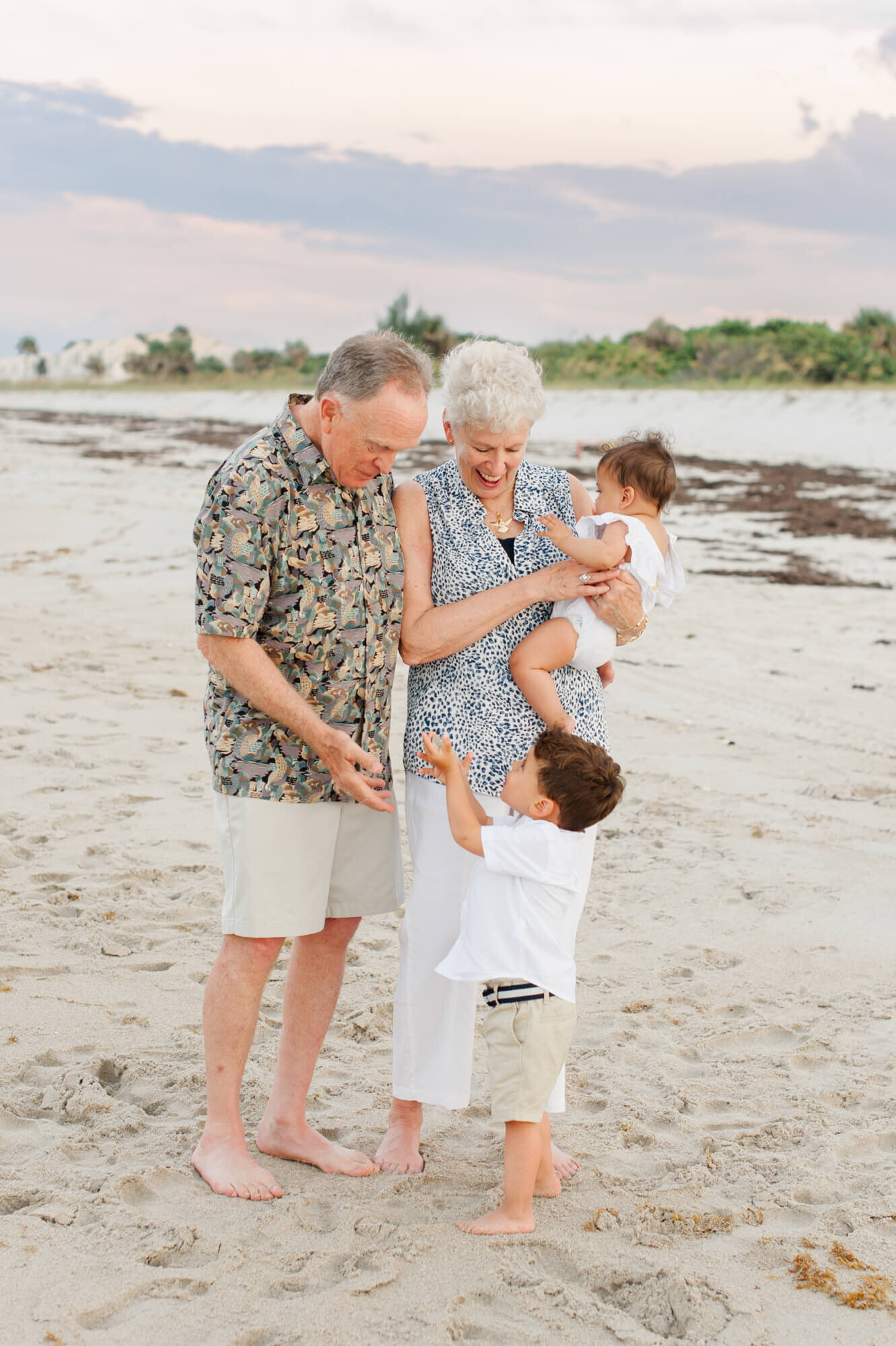 Grandparents holding and laughing with young grandkids during their extended family session