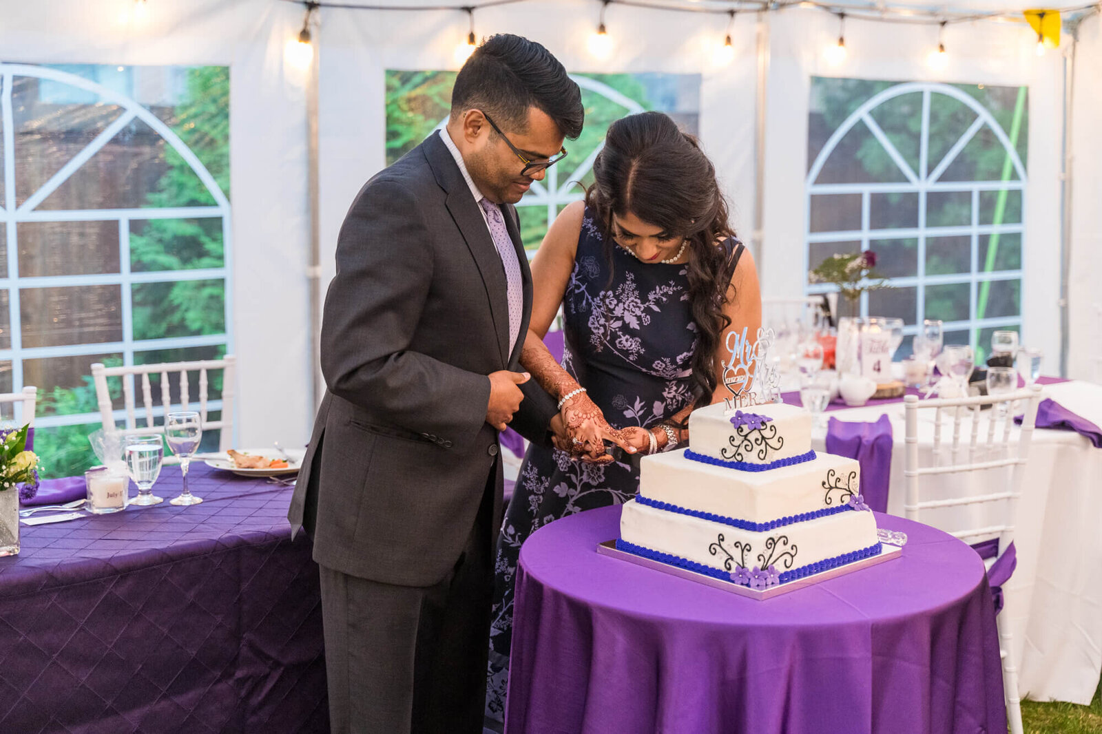 East Indian Wedding couple cutting wedding cake