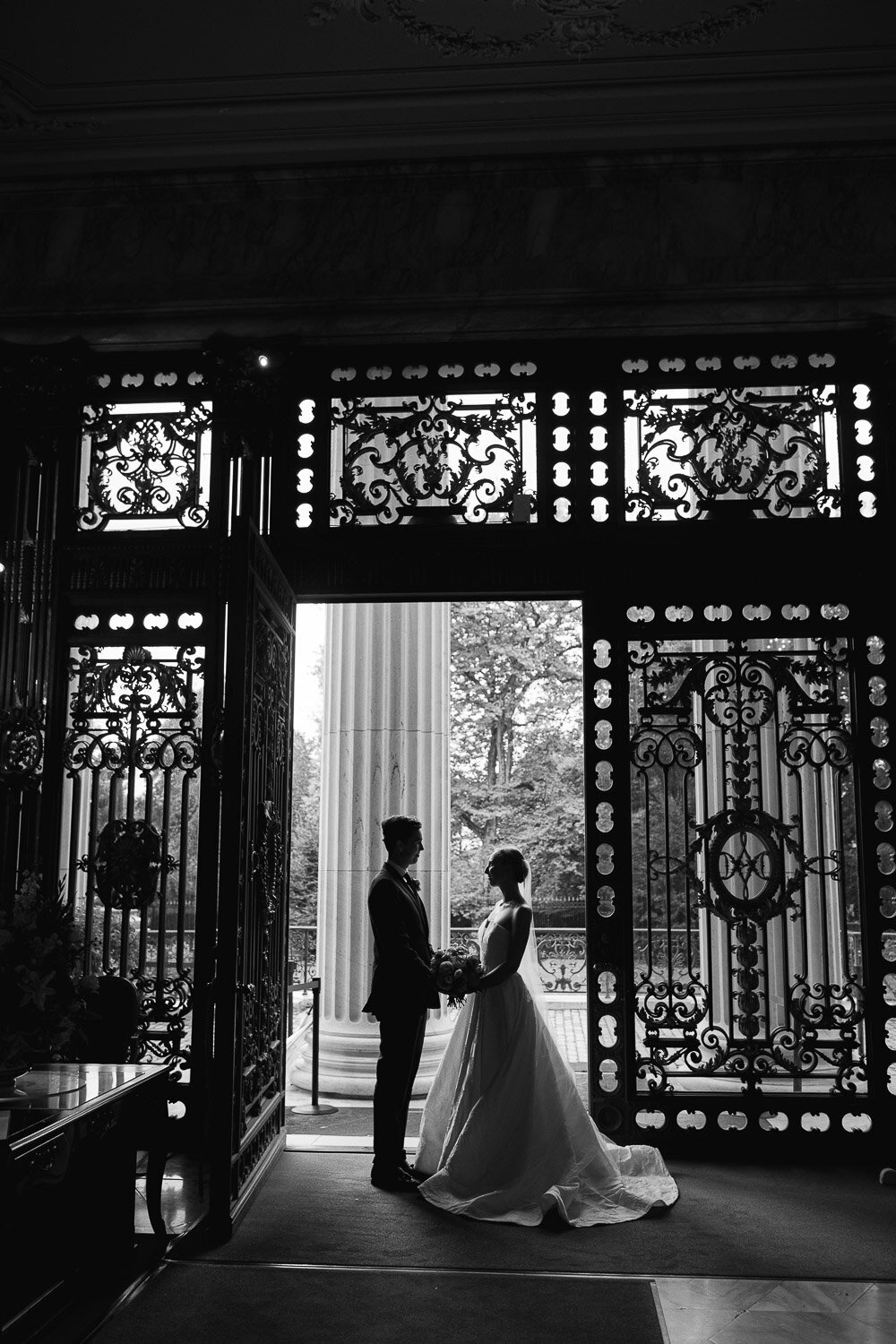 bride and groom silhouette in front of ornate gate