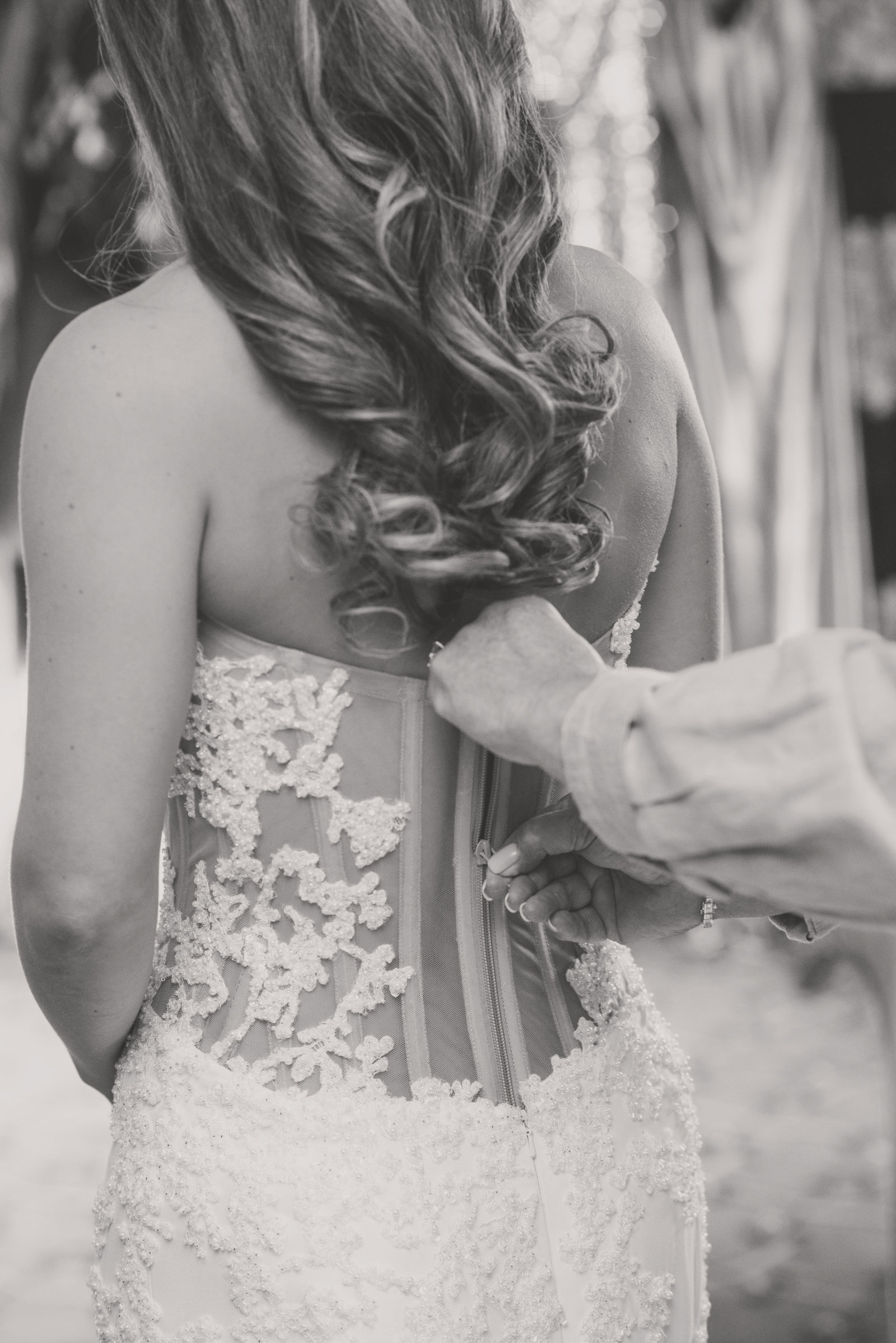 bride getting help with her dress at Glen Head Country Club