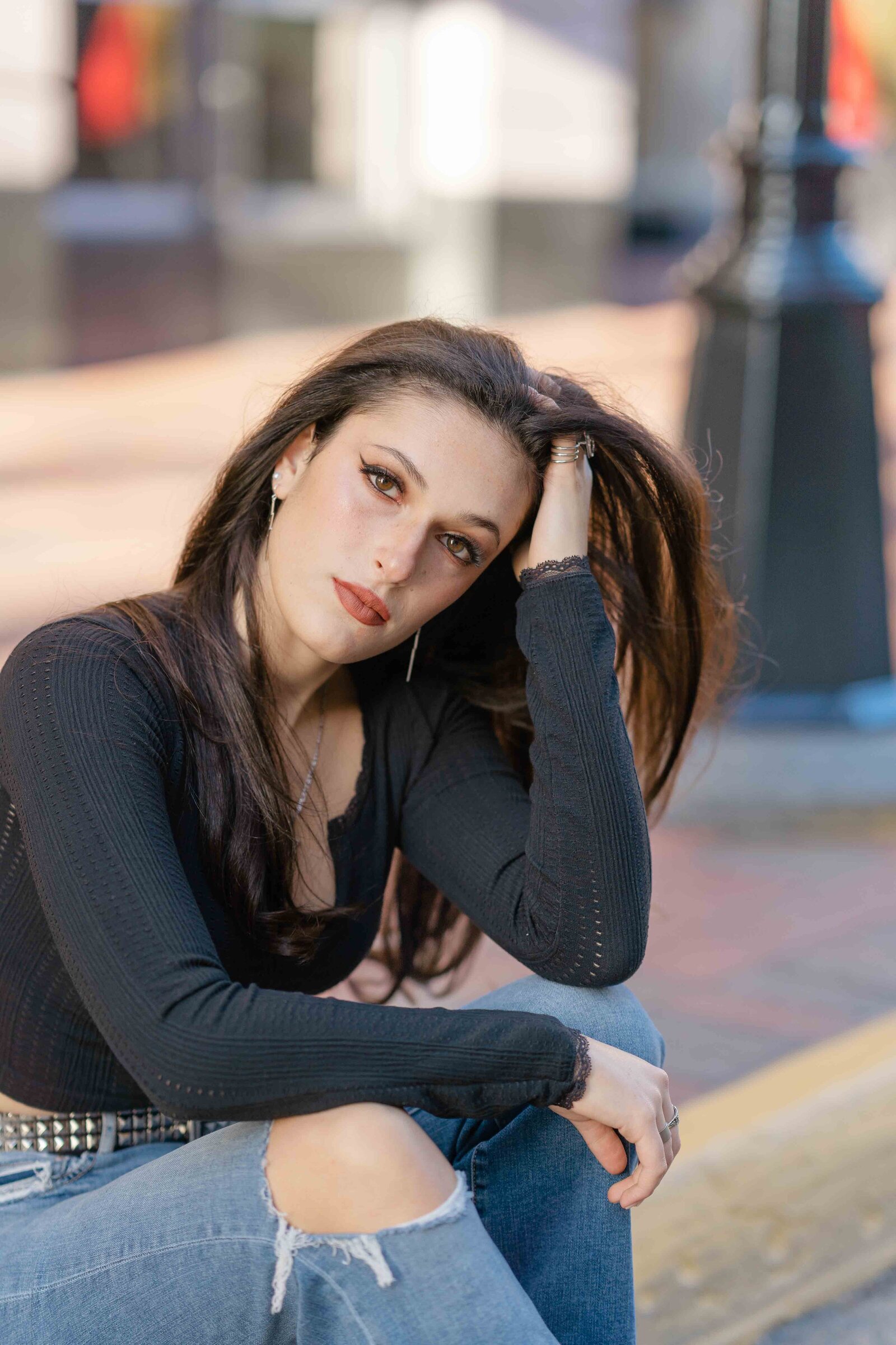 girl sits as she plays with her hair during Reston, VA senior session