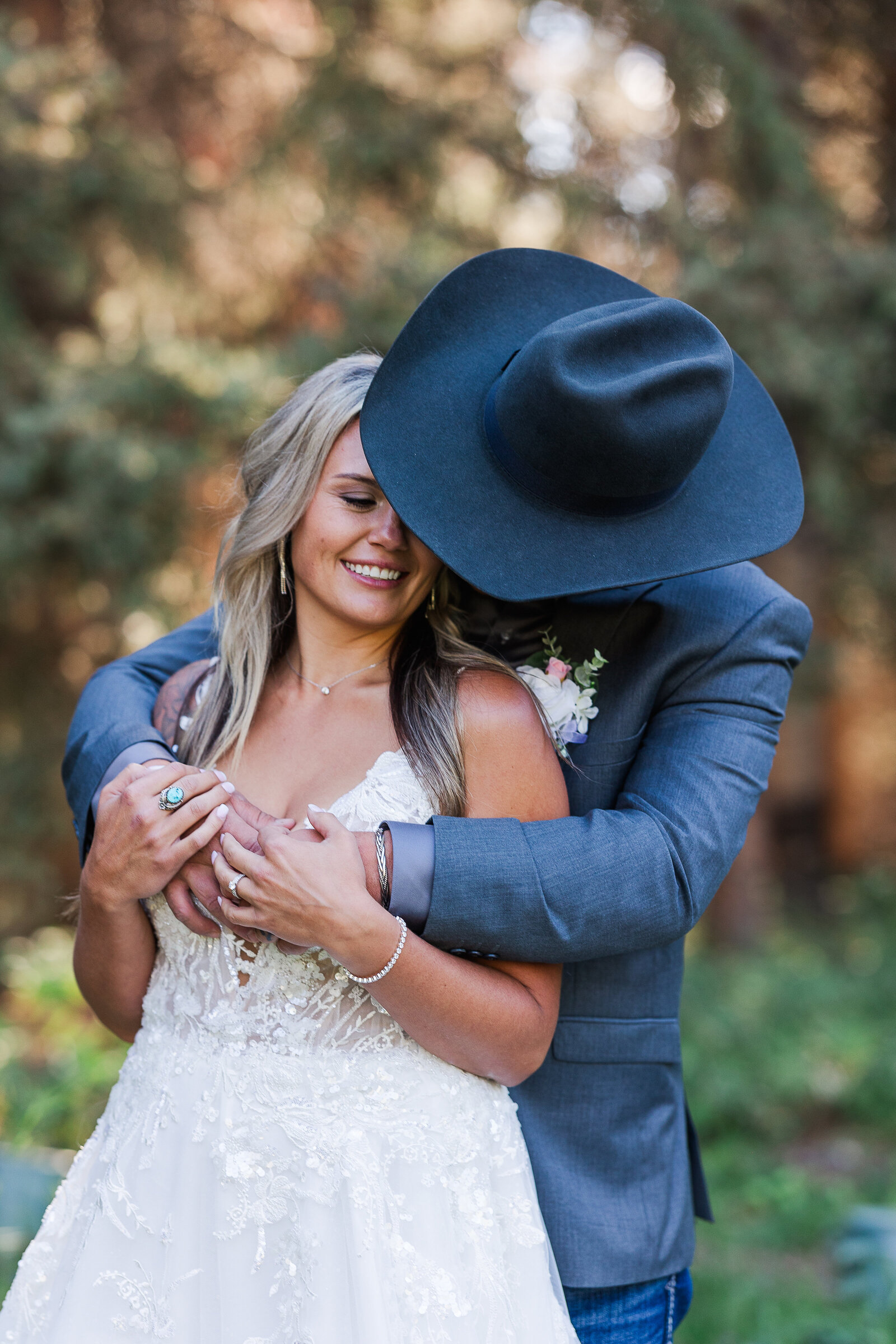Groom holds bride around collar bone and gives are a sweet kiss in Arrowhead Colorado