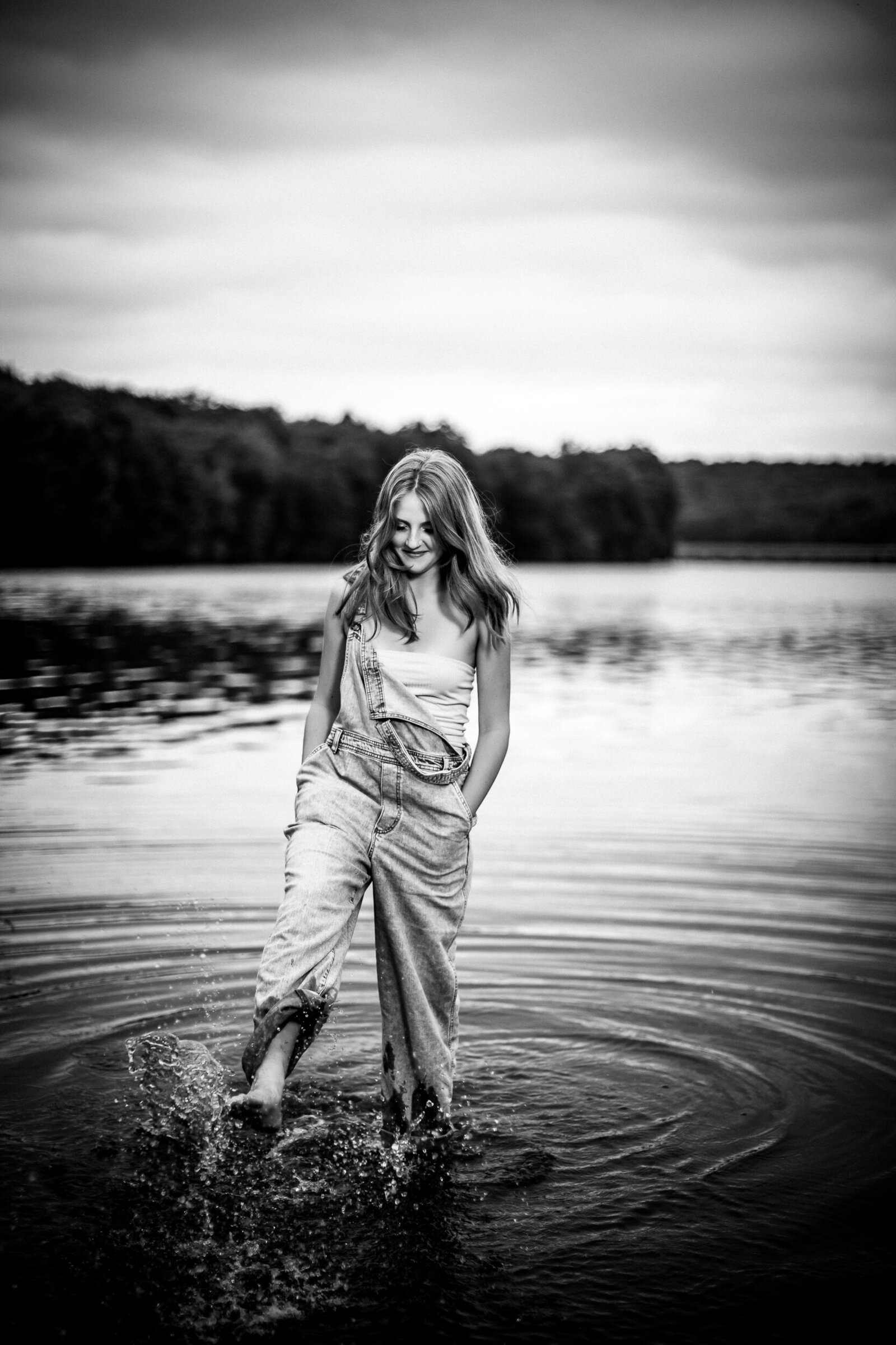 This dynamic black-and-white Picture features a senior girl splashing in the lake