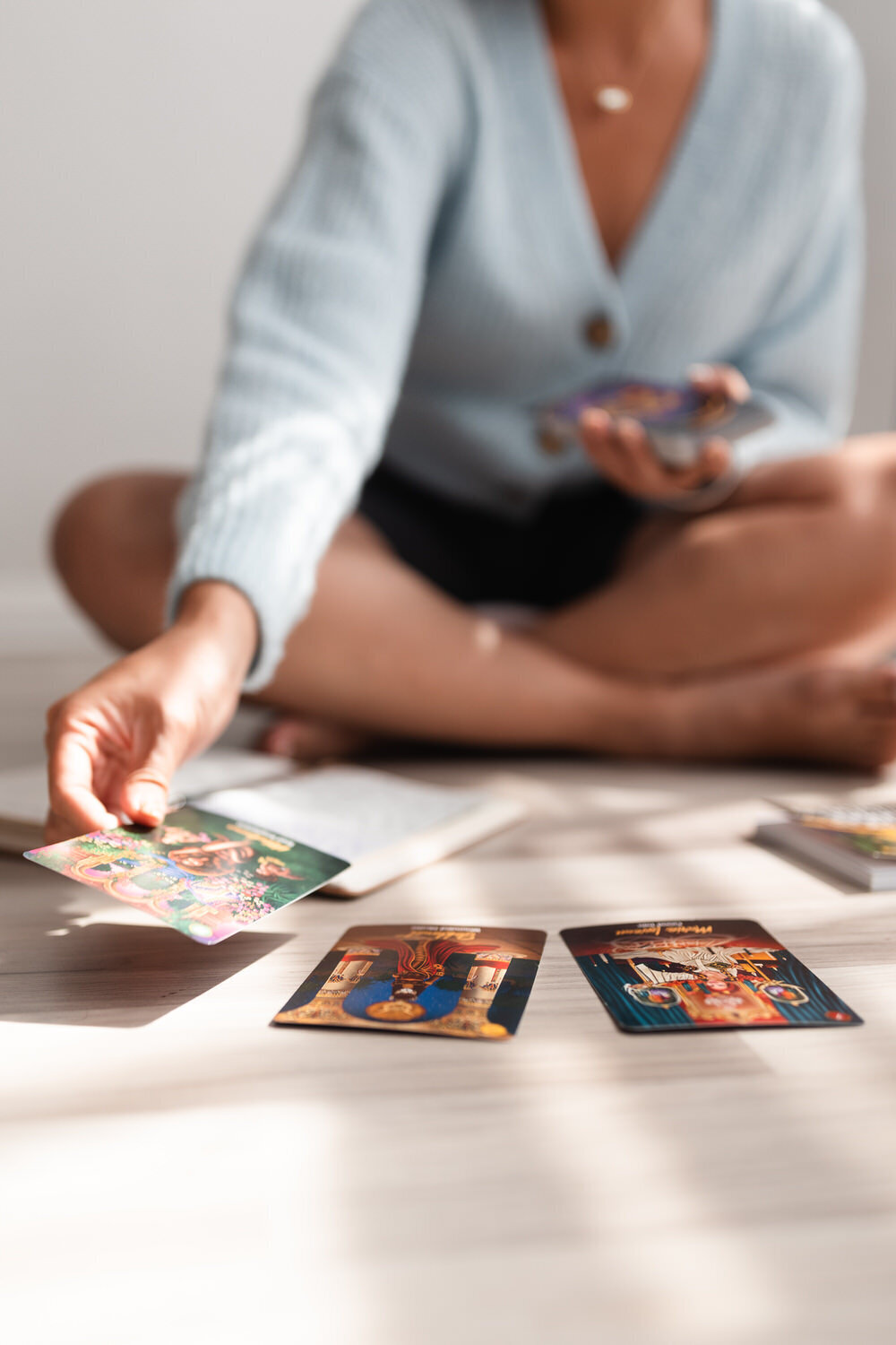 woman sitting on the ground laying tarot cards down in a row