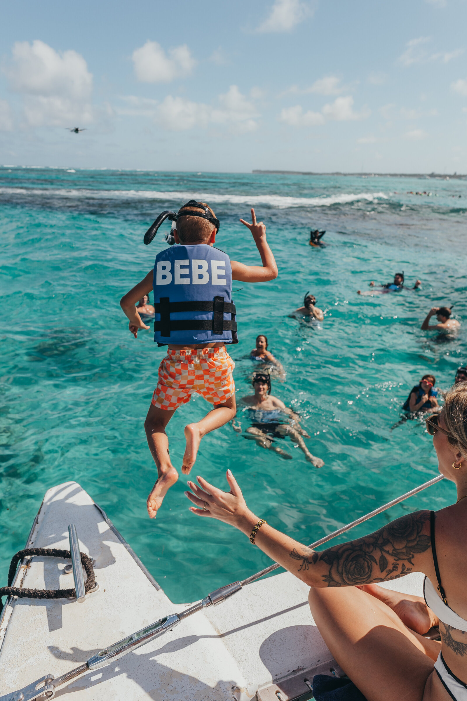 kid jumps from boat into tropical sea