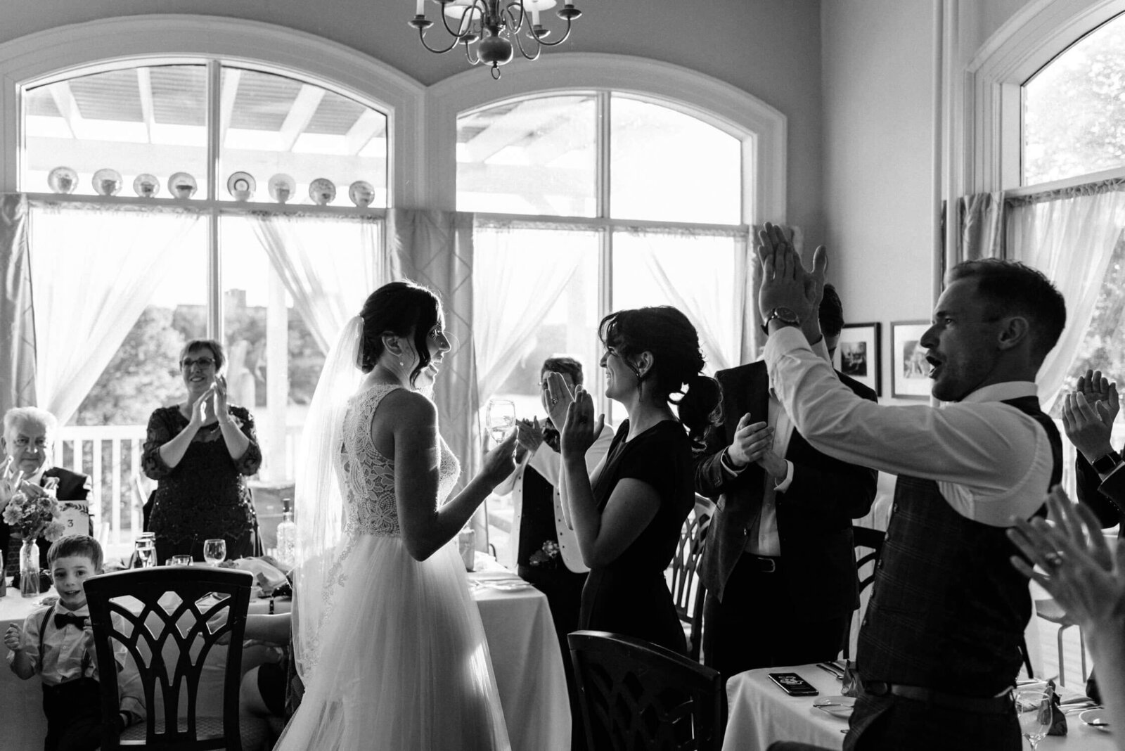 Candid moment of bride celebrating with wedding guests at wedding reception.