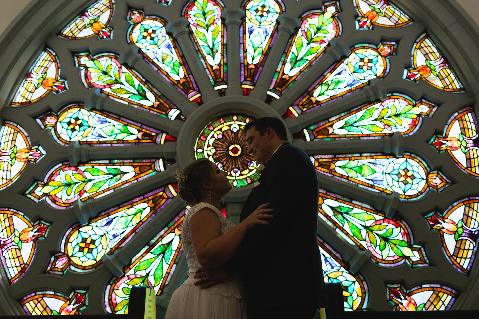 bride and groom portrait with stained glass window at church in ohio