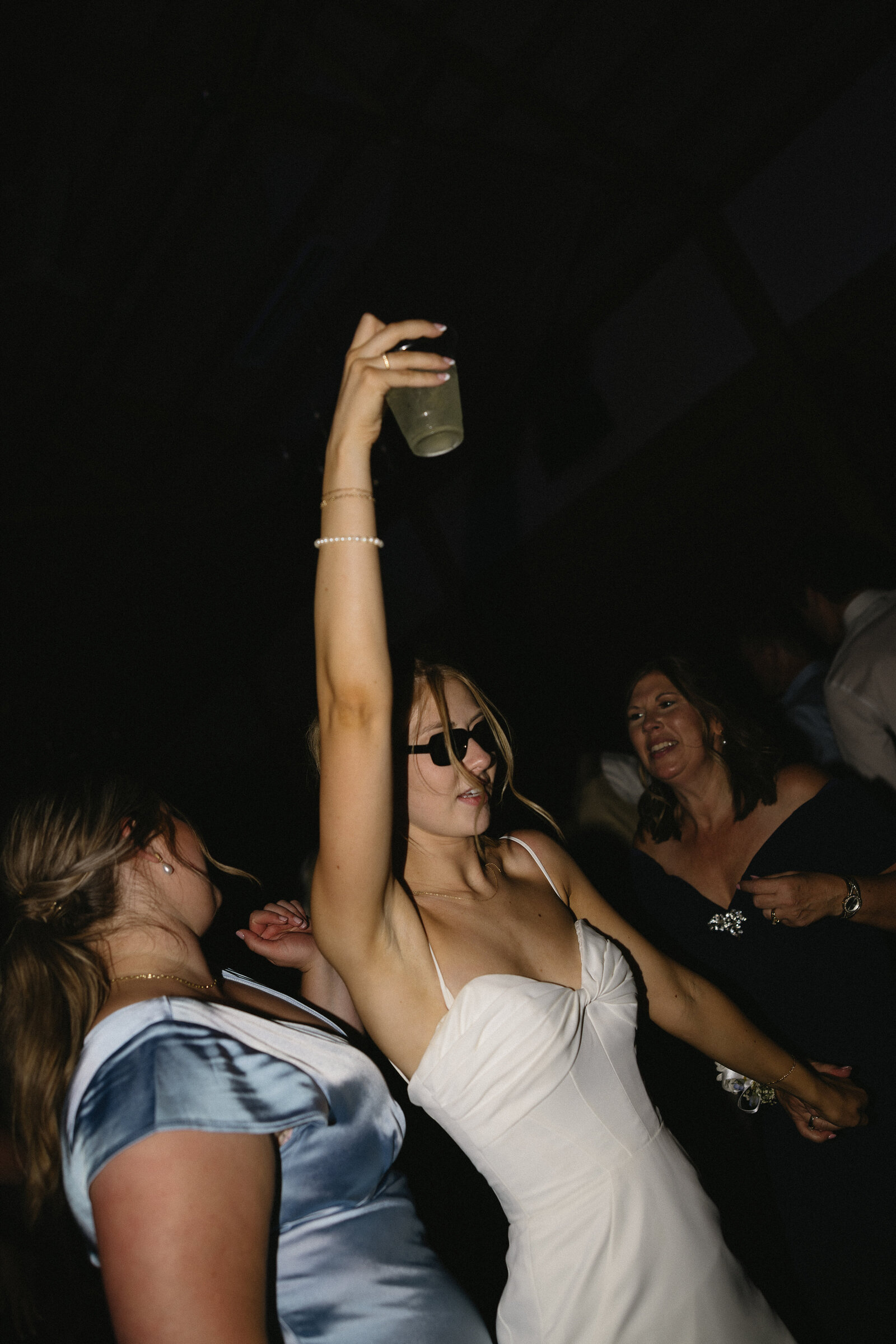 bride and groom partying together at wedding reception with drinks and sunglasses
